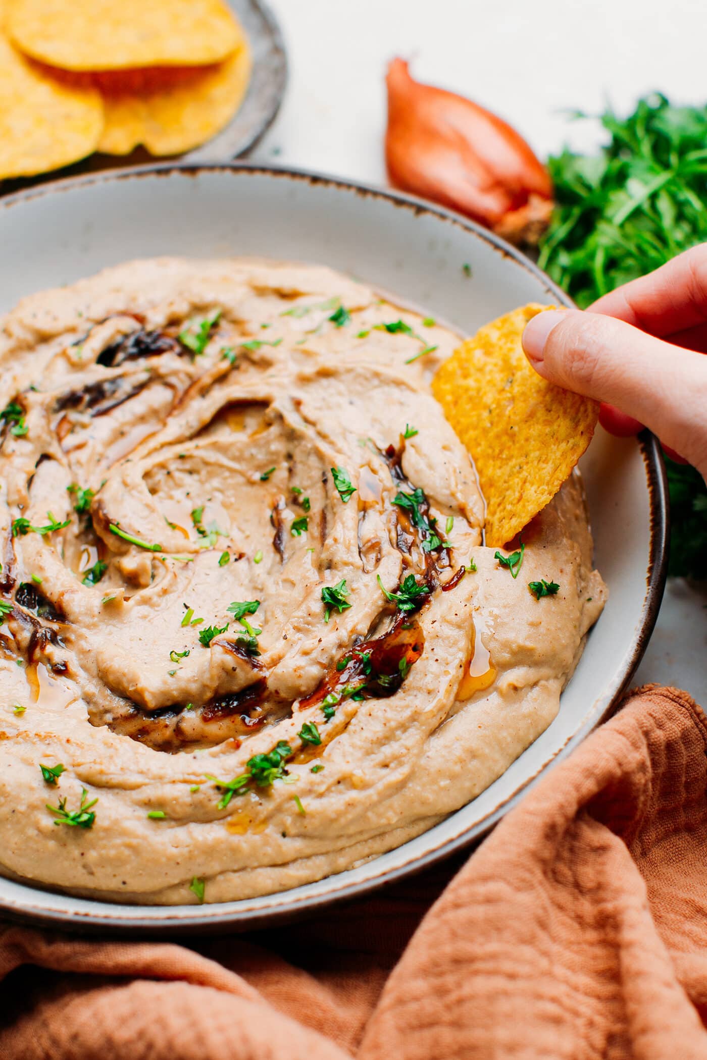 Dipping a tortilla chip in hummus.