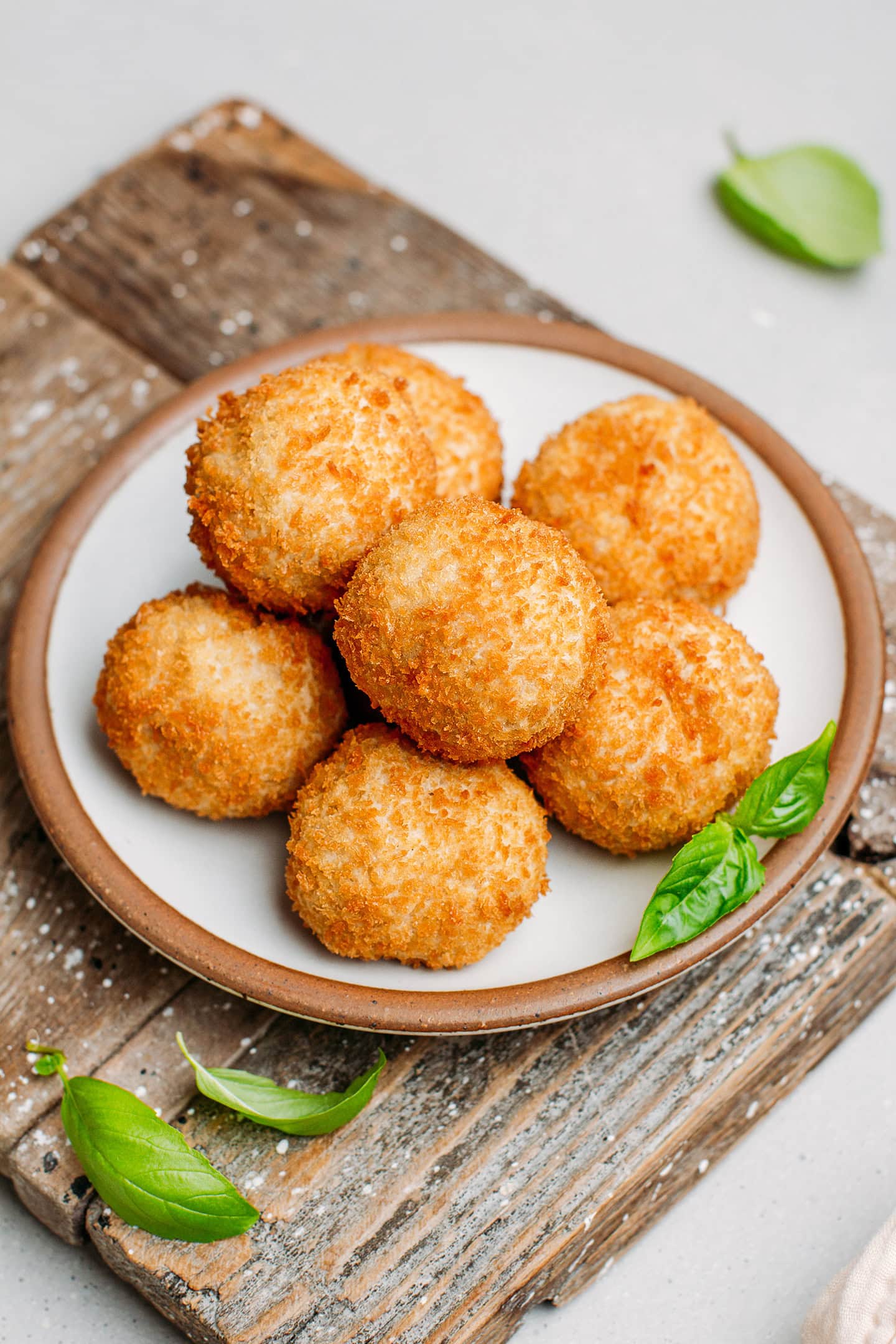 Stacked fried cheese balls on a plate.