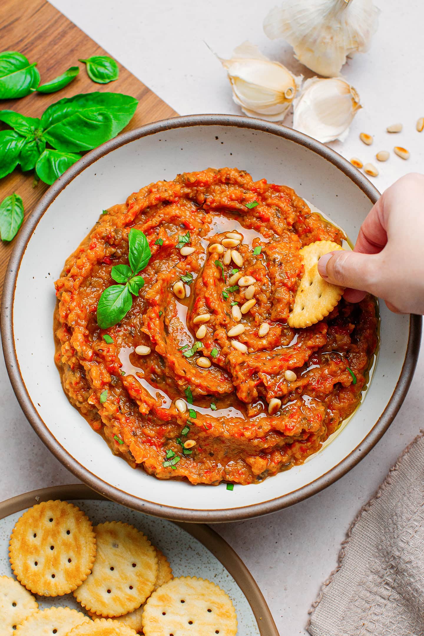 Bowl with eggplant and tomato dip topped with toasted pine nuts.