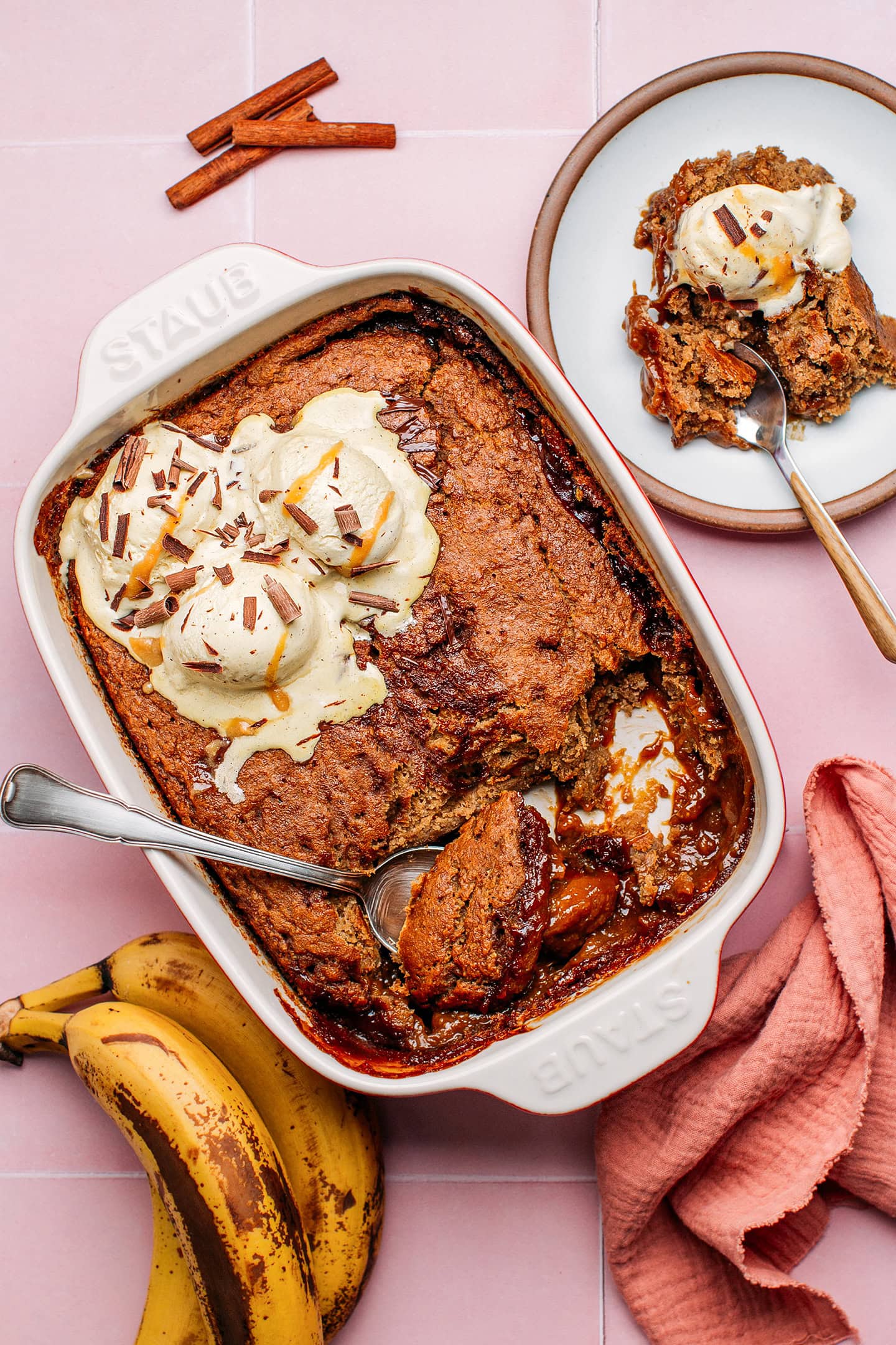 Banana pudding with caramel sauce and vanilla ice cream in a baking dish.