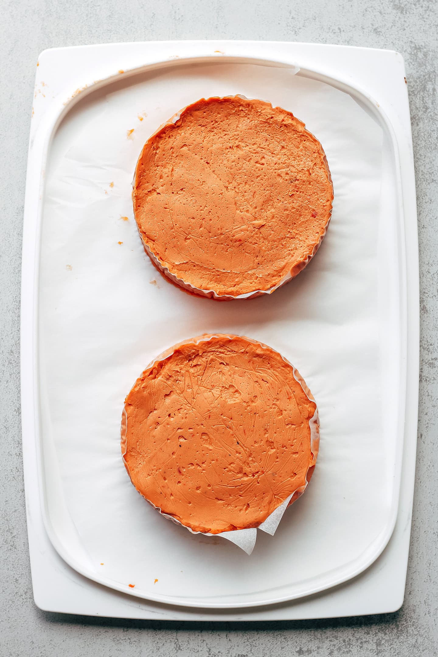 Wheels of tomato camembert on parchment paper.