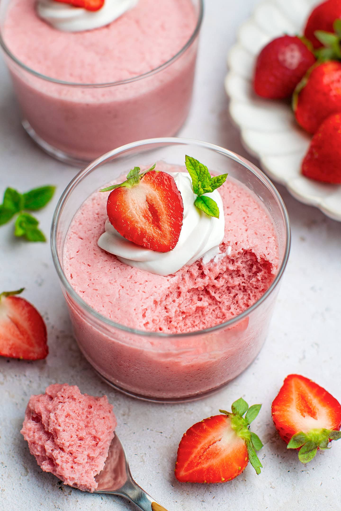 Strawberry Mousse topped with coconut cream, mint leaves, and strawberries.