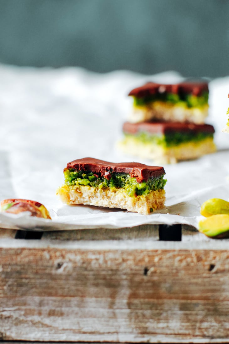 Close-up of a pistachio bar topped with chocolate ganache.