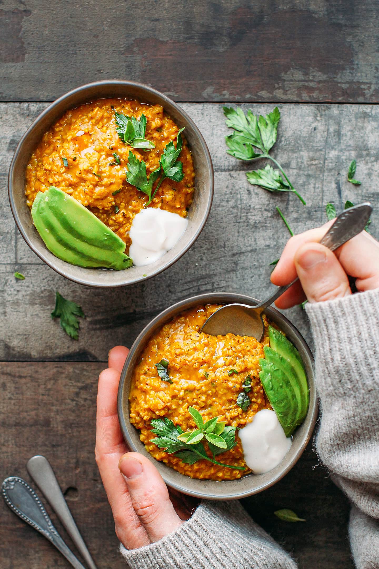 Two bowls of masala oats topped with avocado and coconut yogurt.