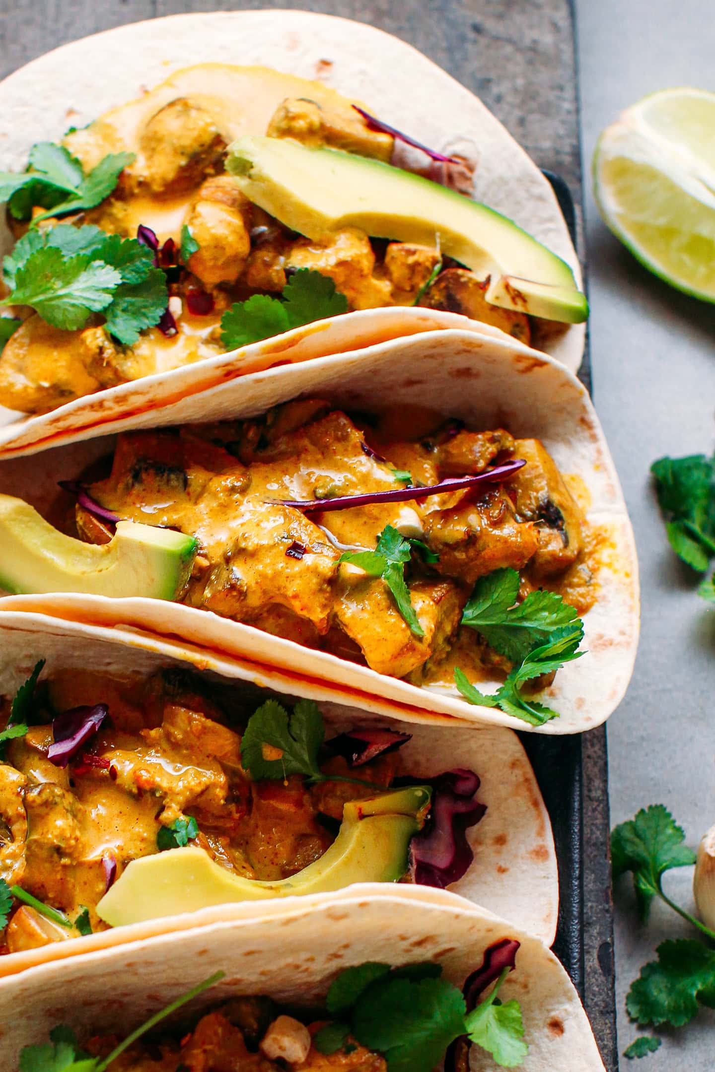 Close-up of a taco filled with mushrooms and curry sauce.