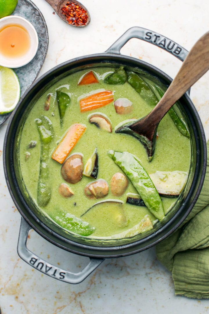 Snow peas, eggplants, mushrooms, and carrots in a pot.