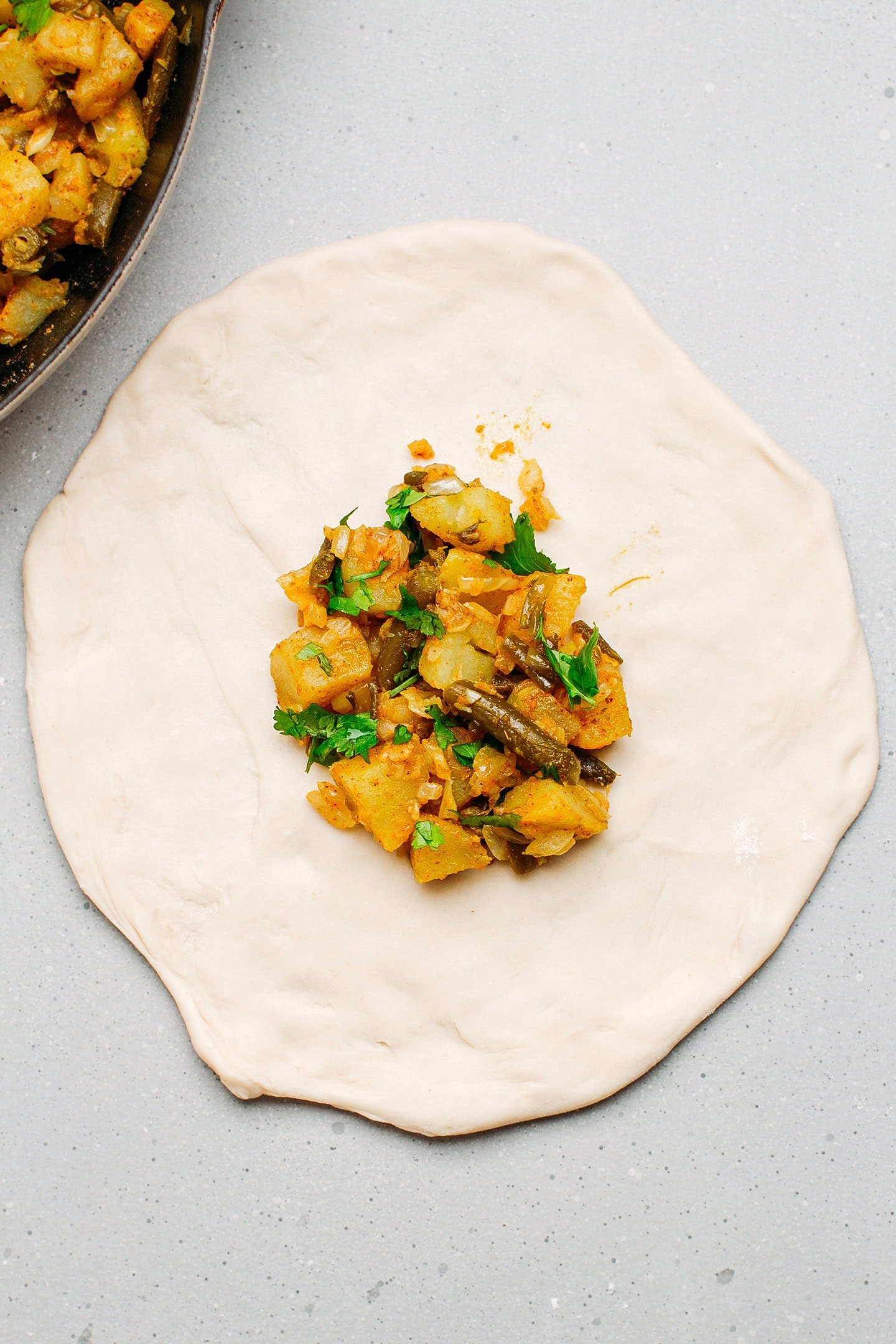 Potato filling on top of a naan dough.