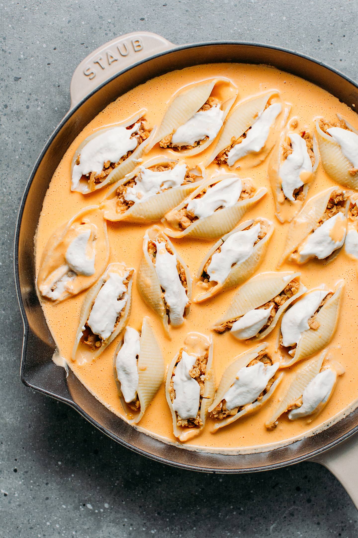 Stuffed shells topped with buffalo sauce and cashew cheese sauce.