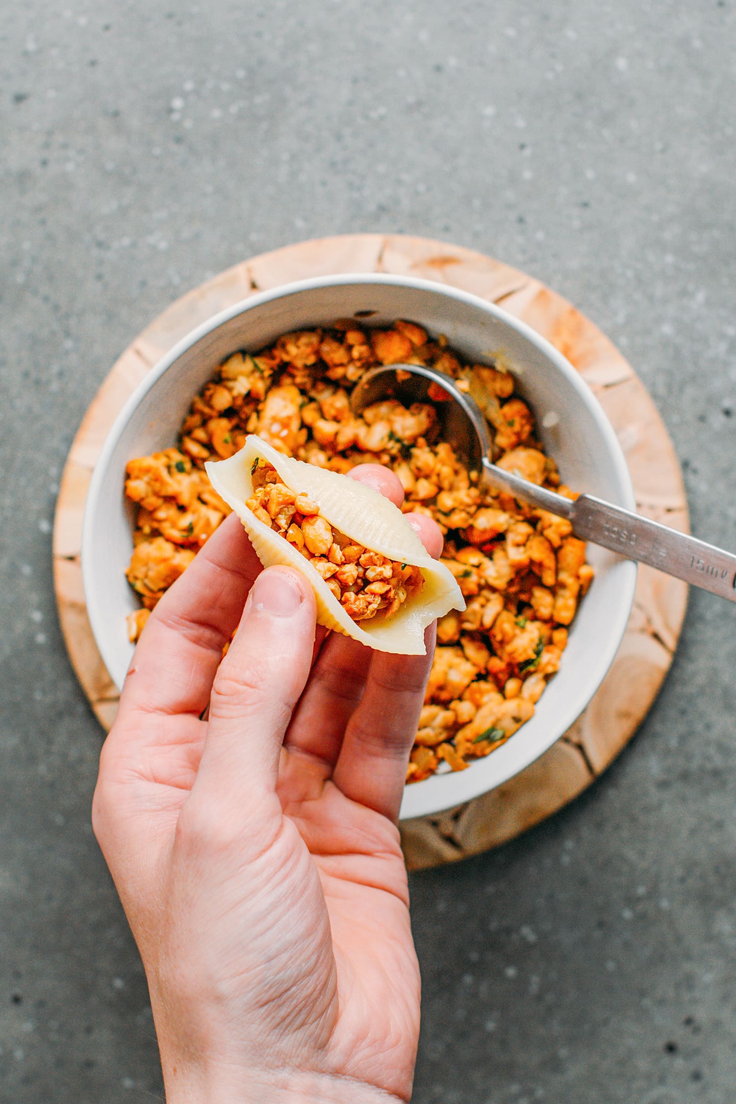 Filling cooked shells with tempeh scramble.