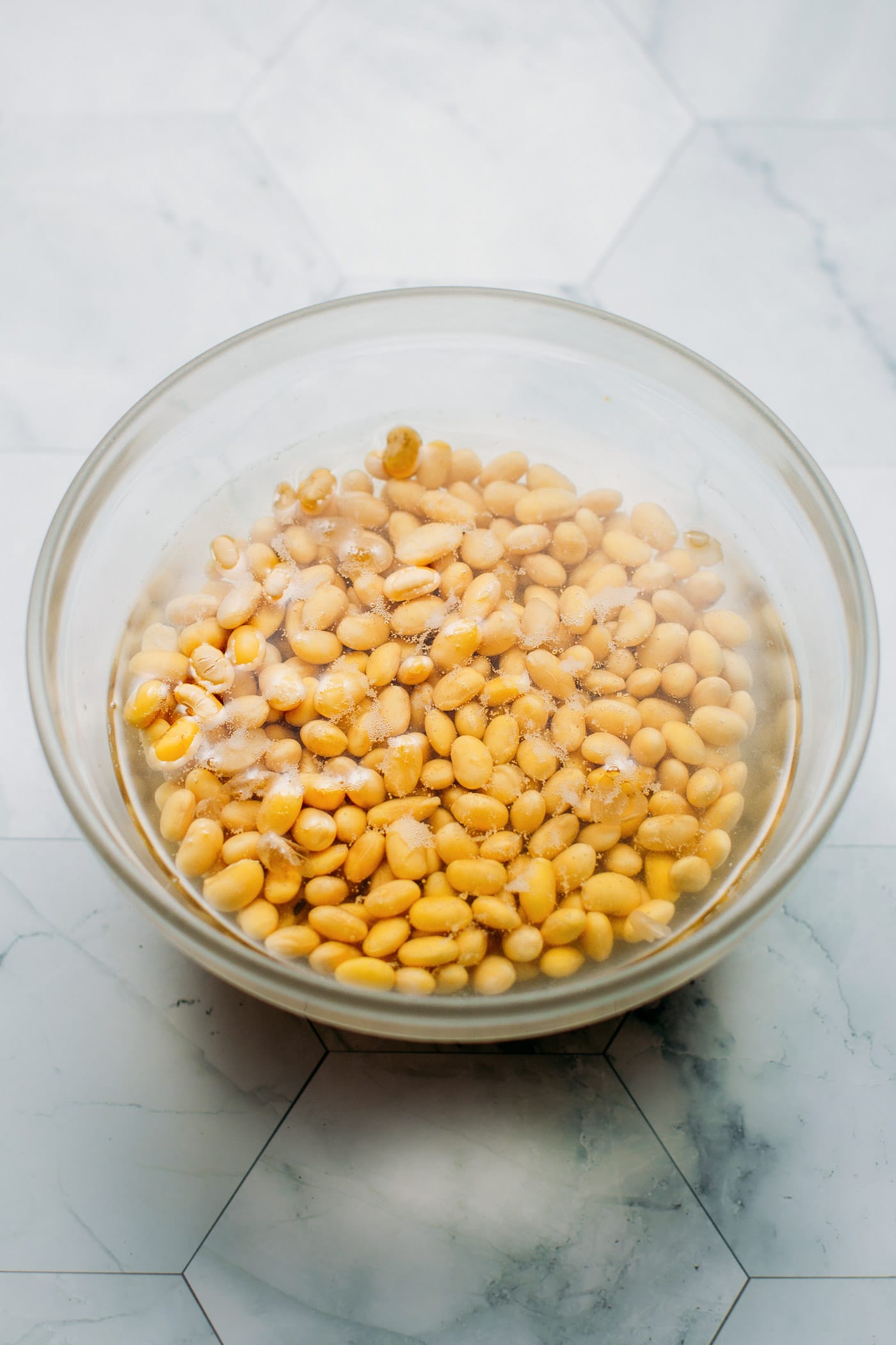 Soybeans soaking in a bowl of water.