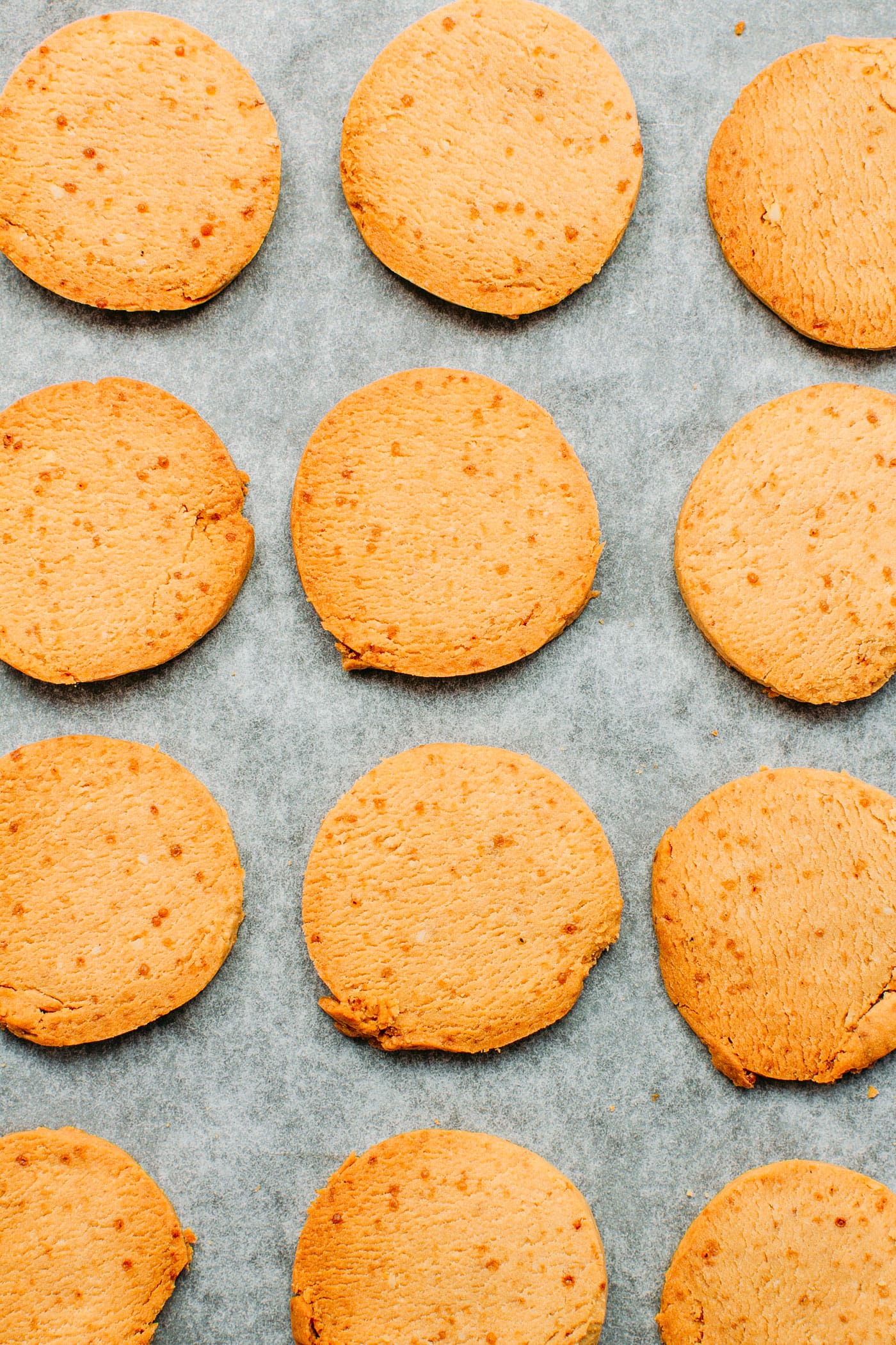 Vegan shortbread cookies on a baking sheet with parchment paper.