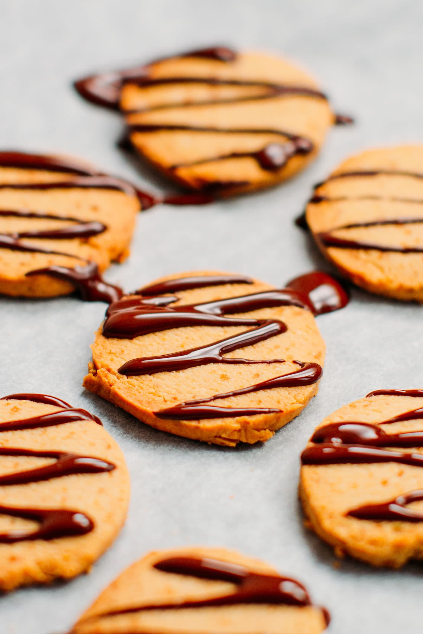 Close up of vegan shortbread cookies with melted chocolate drizzle.