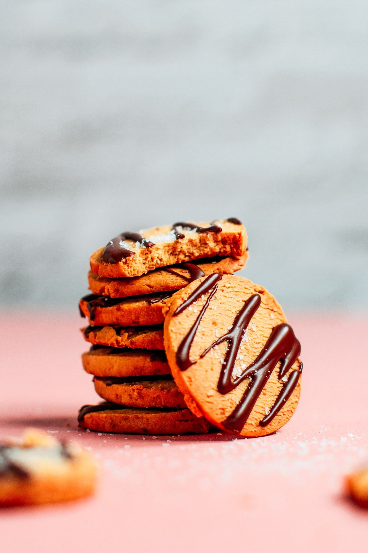 Stack of vegan shortbread cookies with chocolate drizzle and sea salt.