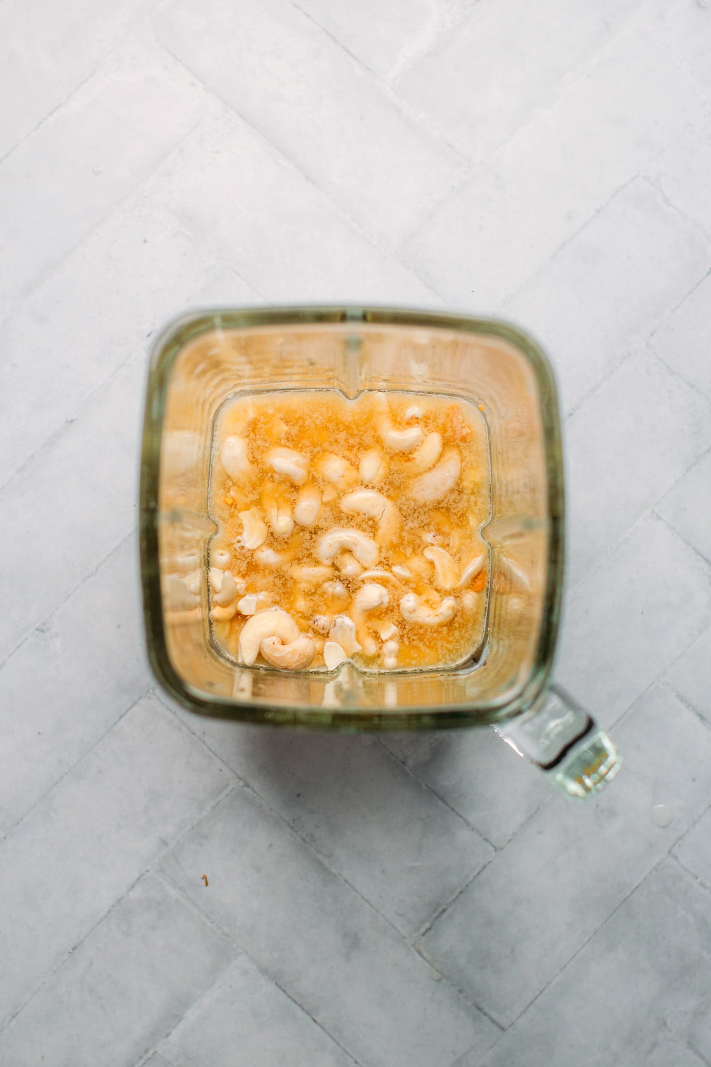 Cashews in a blender with nutritional yeast.