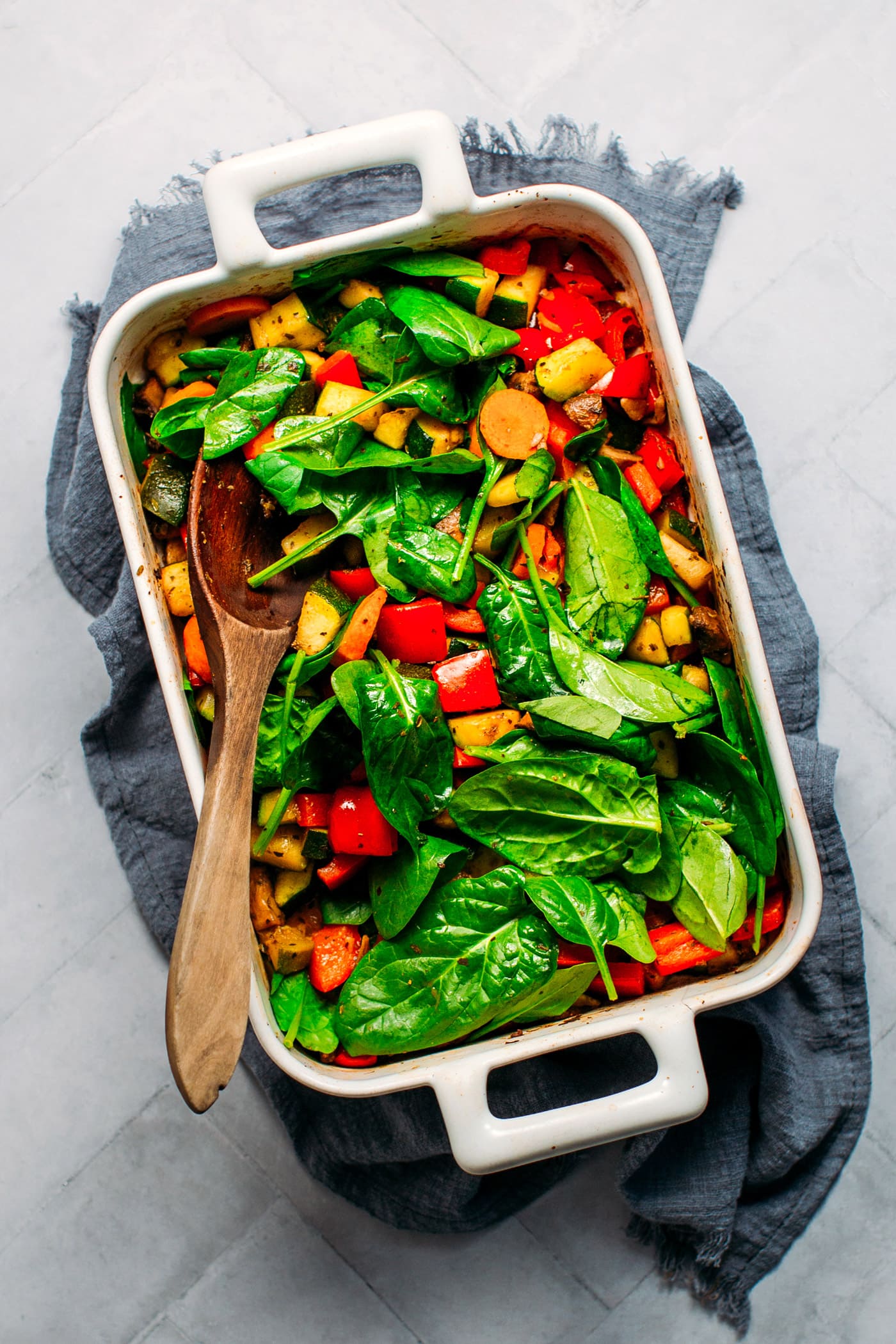 Roasted veggies in baking dish with spinach.