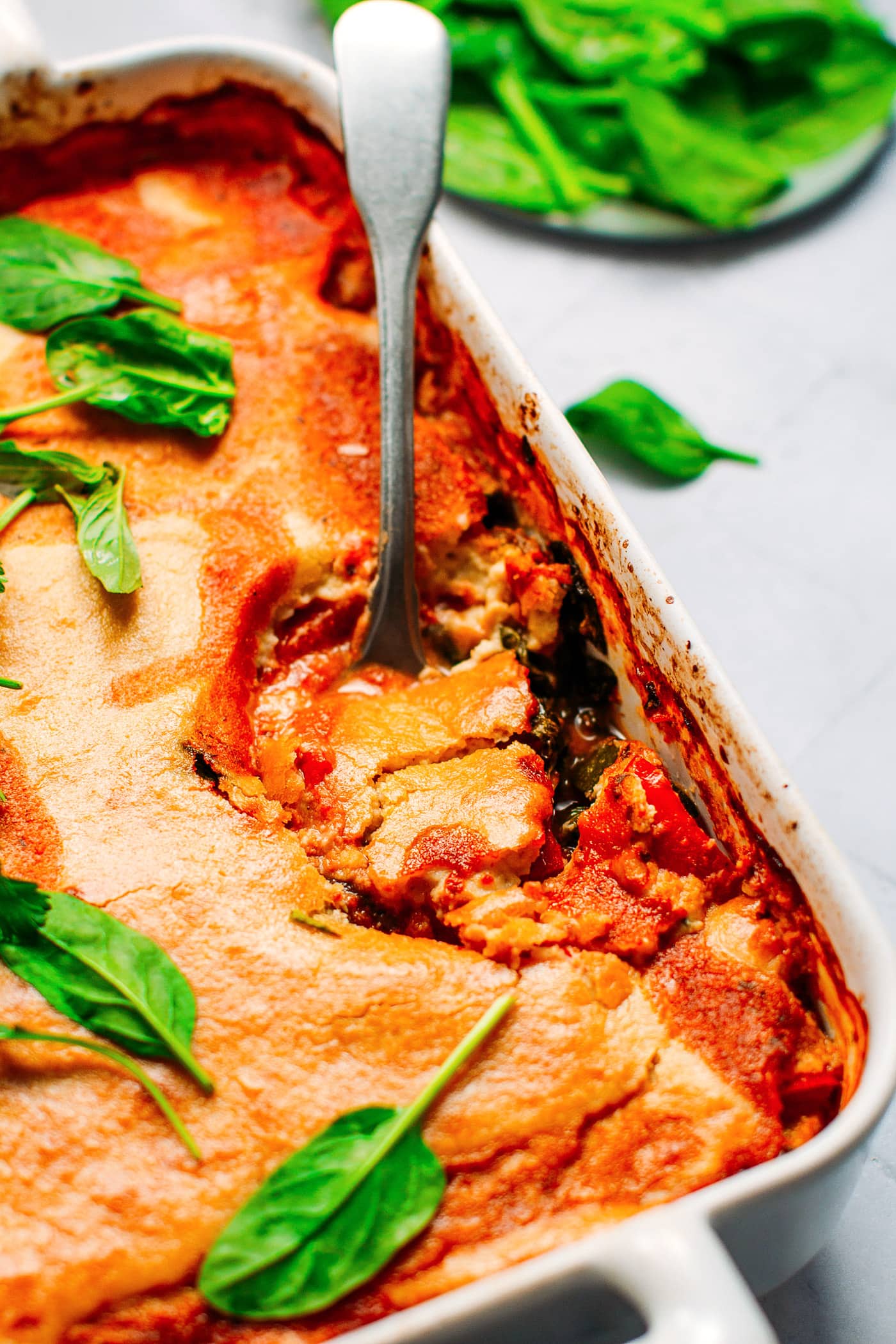 Cheesy Vegan Vegetable Bake with spoon.