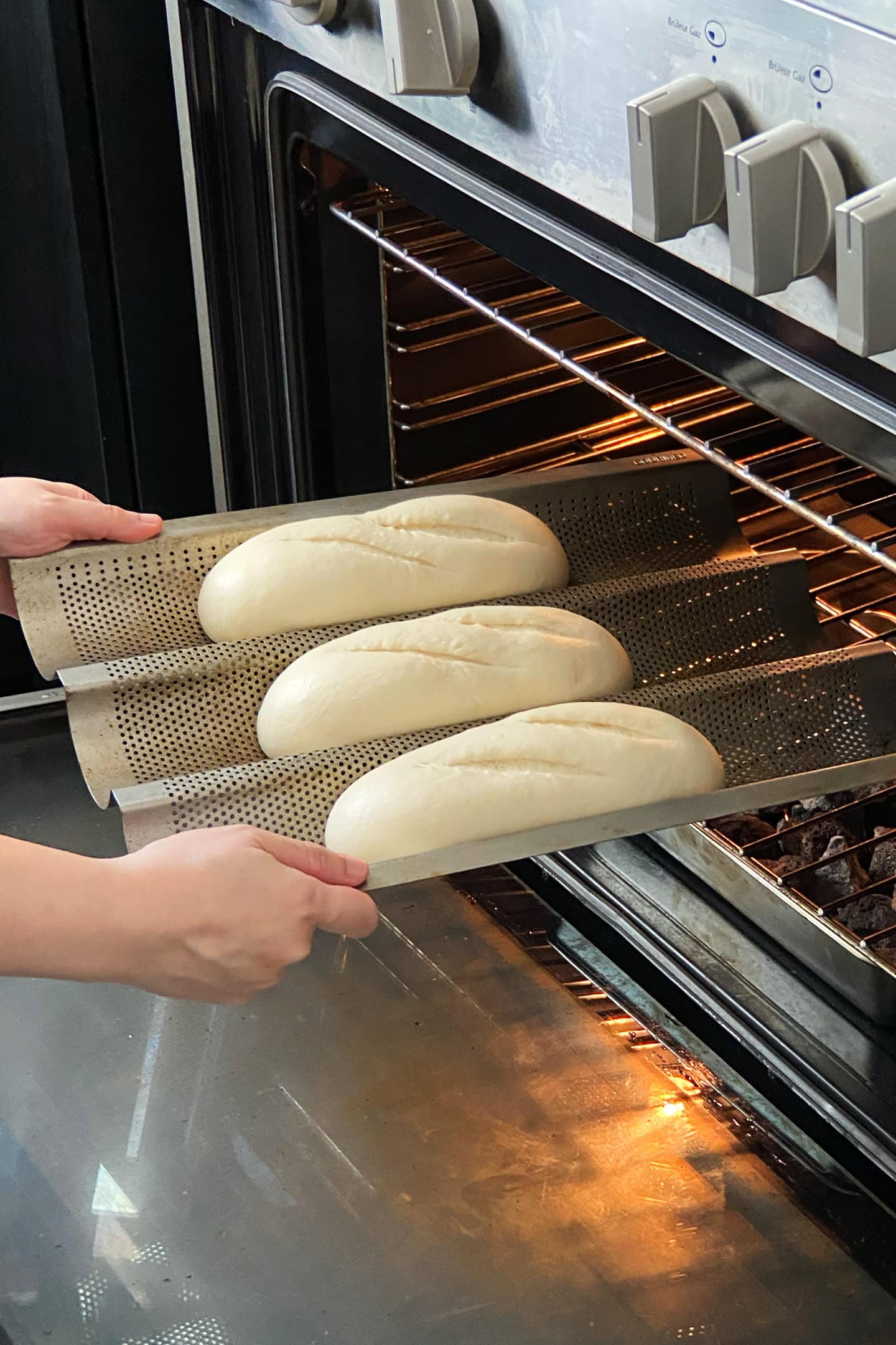 Placing baguette pan into an oven.