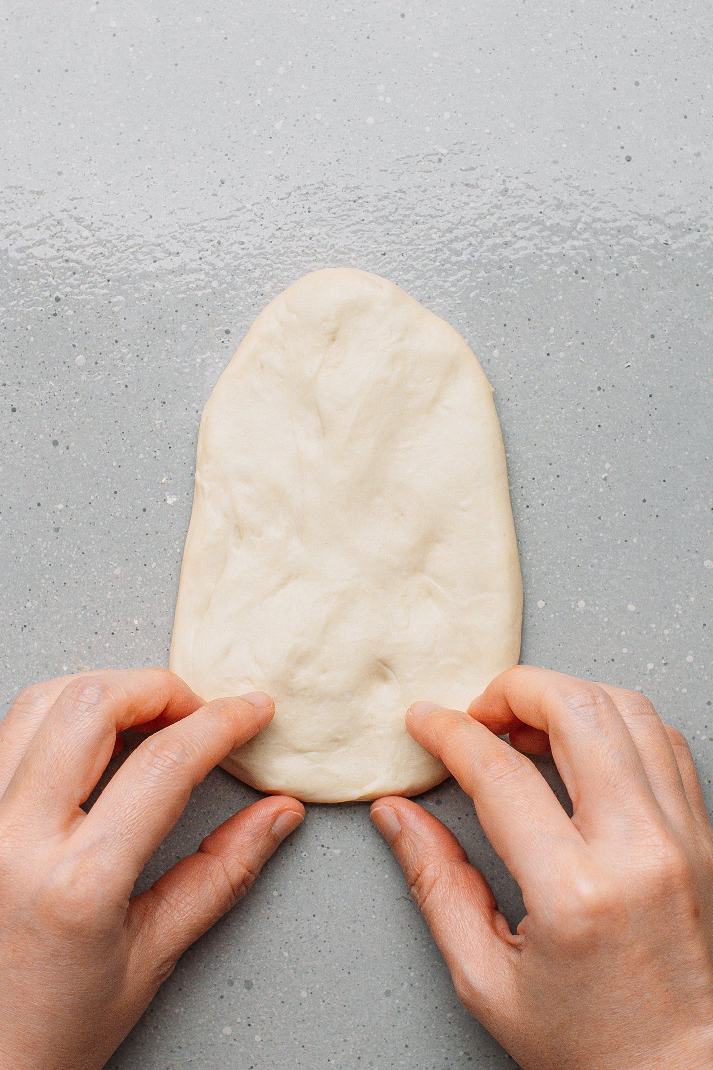 Starting to flatten a ball of dough.