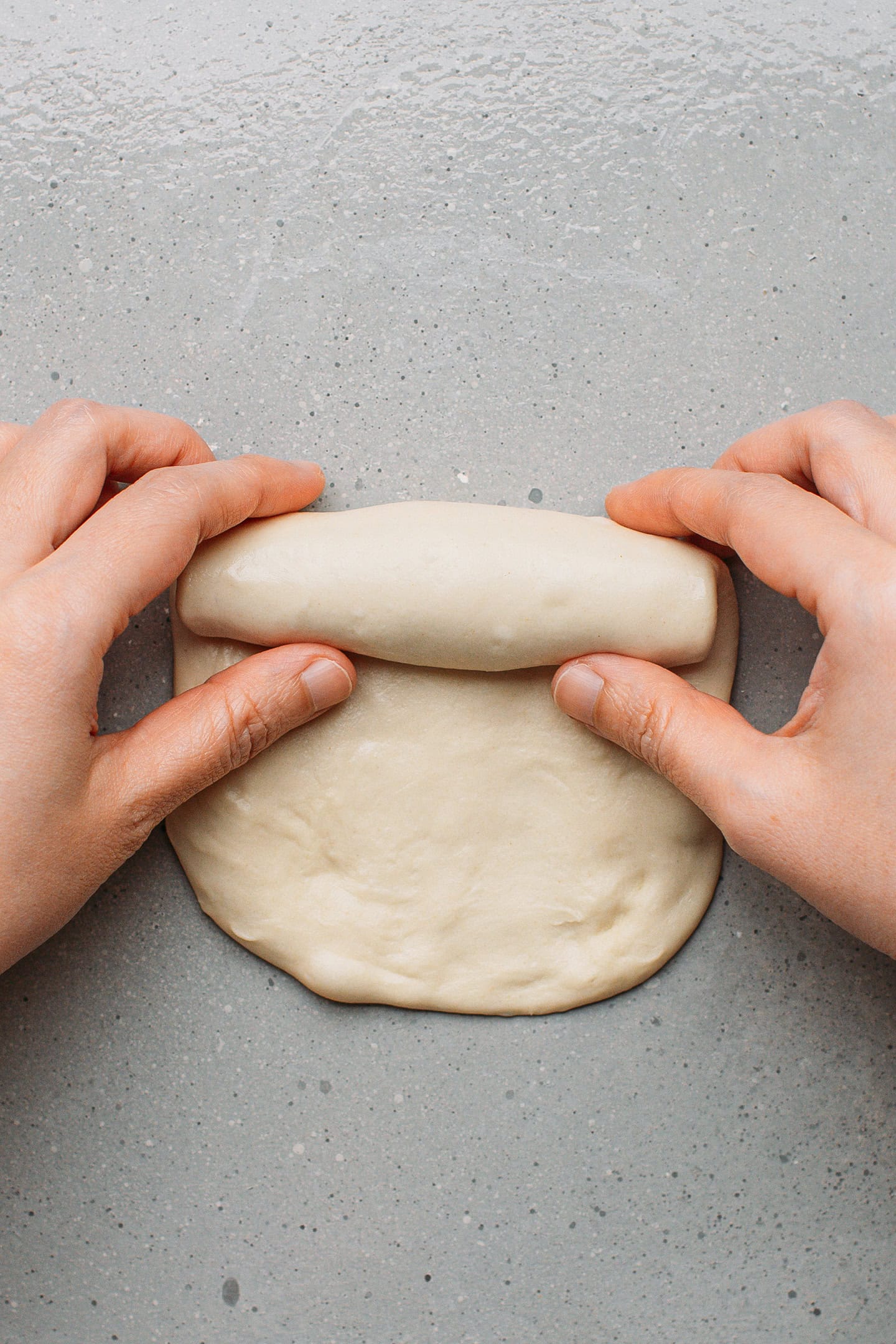 Rolling dough into a long log.