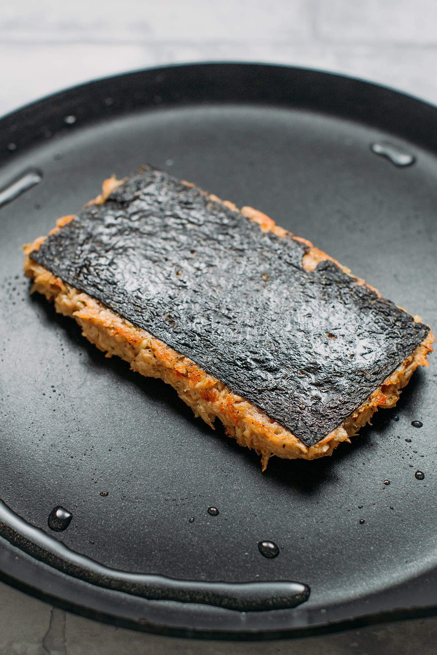 Vegan Fish Fillet sautéed in oil in a skillet.