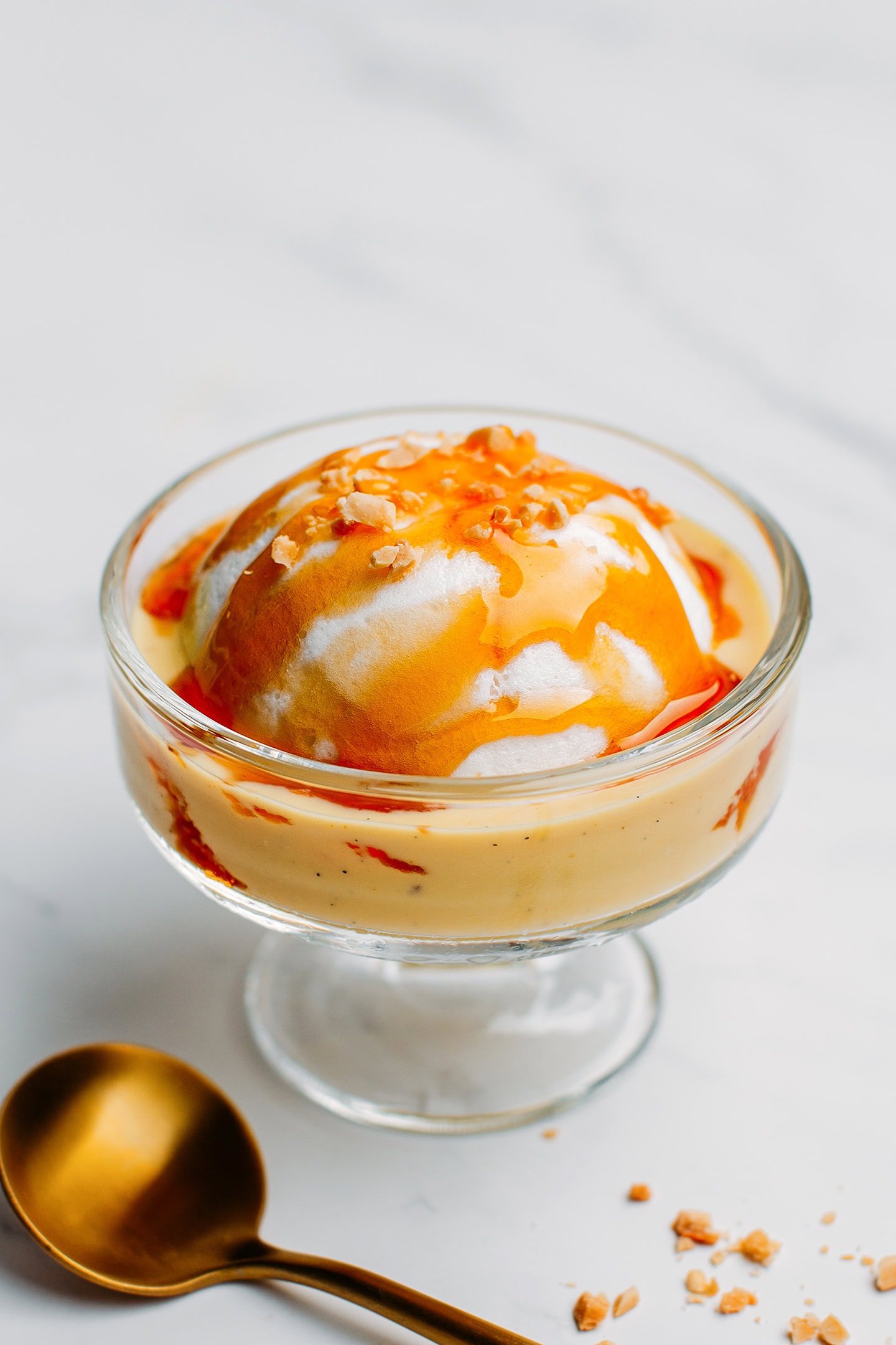 Vegan Île Flottante drizzled with caramel sauce and crushed peanuts.