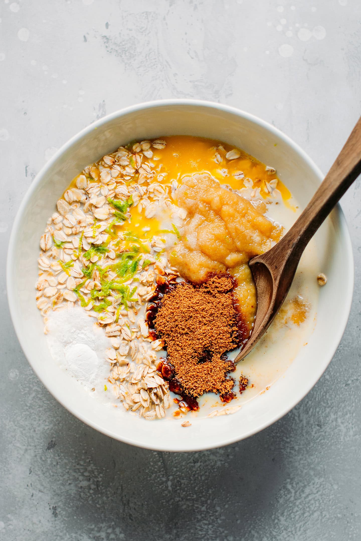 Rolled oats, apple sauce, coconut sugar, and lime zest in a bowl.