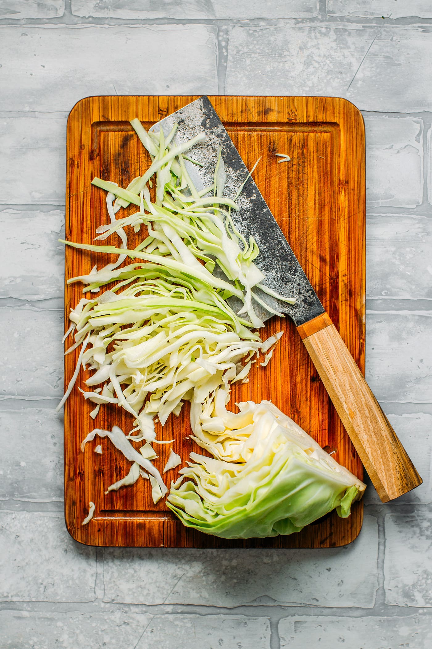 Shredded green cabbage on a cutting board