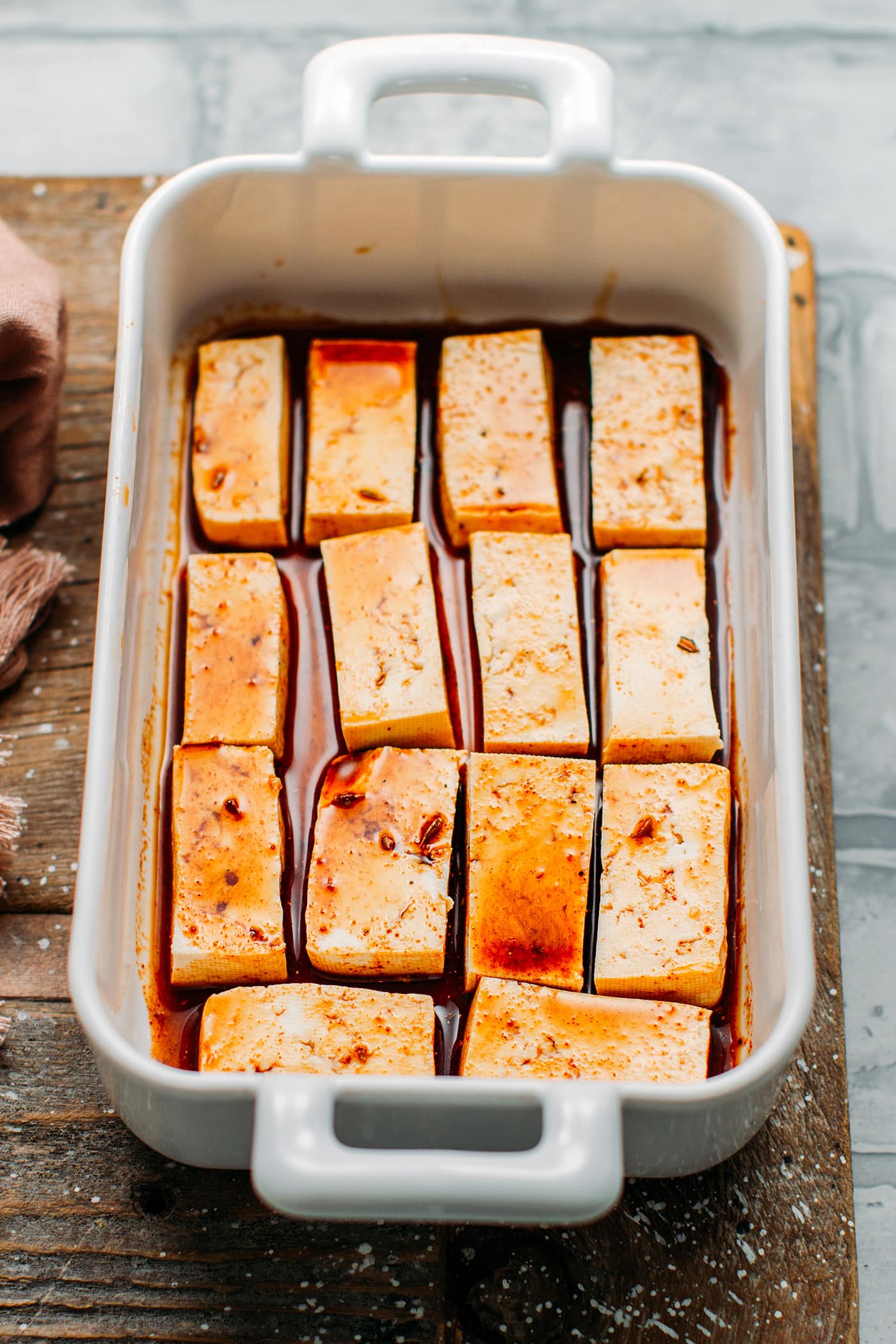 Tofu marinating in soy sauce, maple syrup, and chili powder