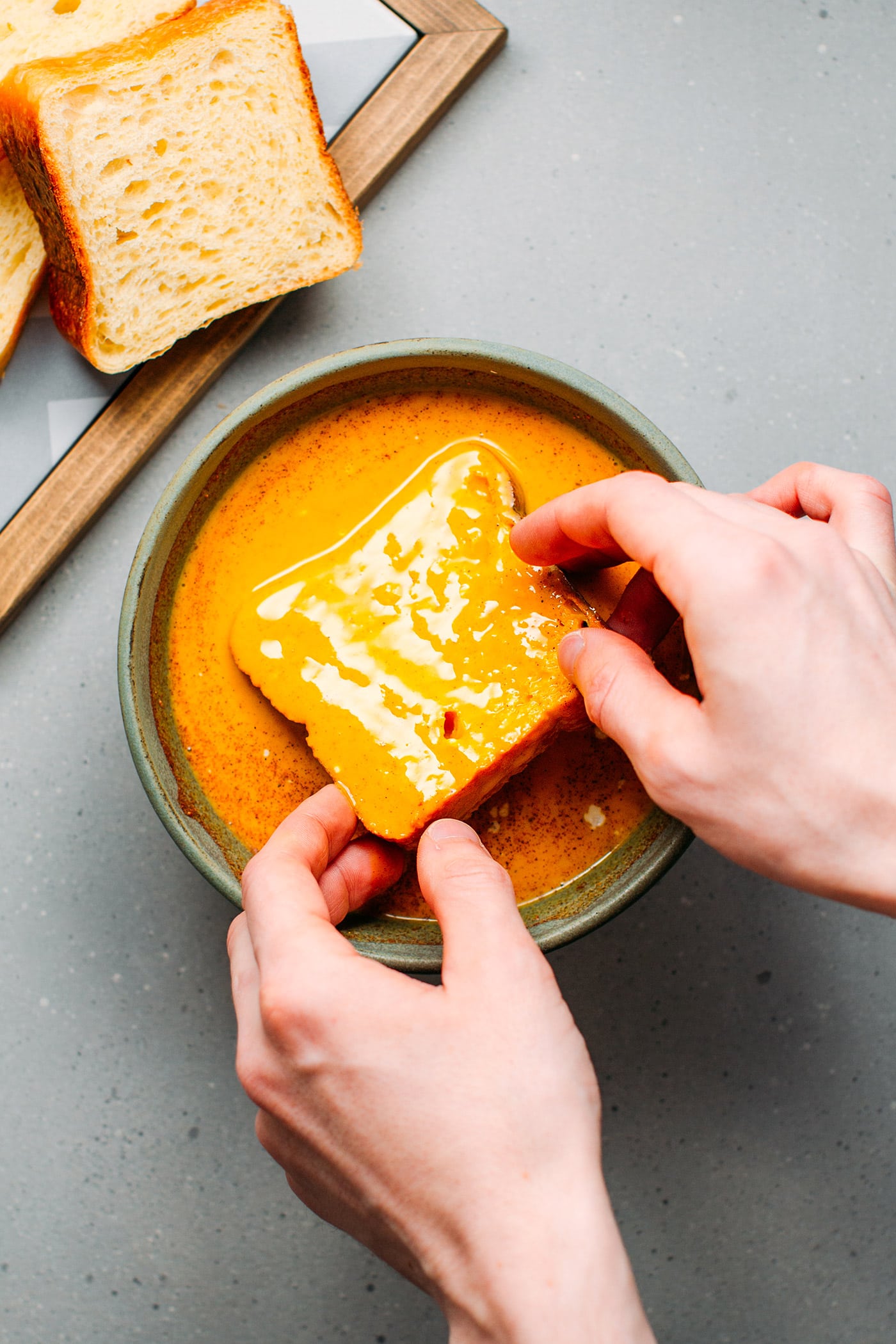 Dipping sandwich bread to make french toast