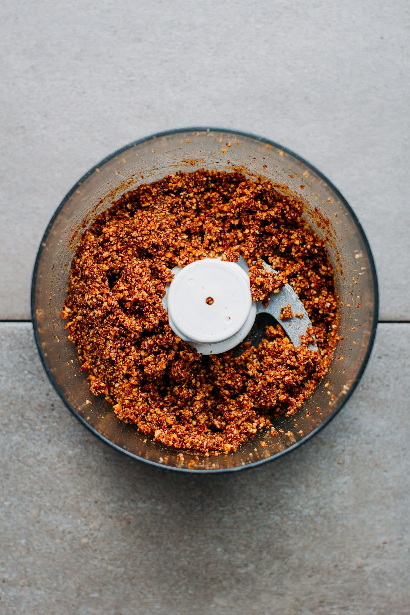 Chopped pecans in a food processor bowl