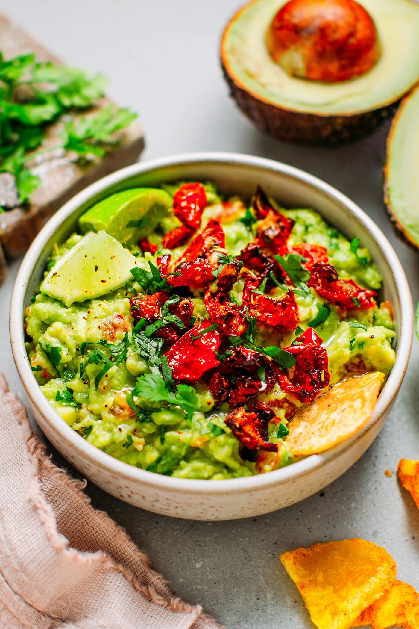 Guacamole in a bowl topped with sun-dried tomatoes.