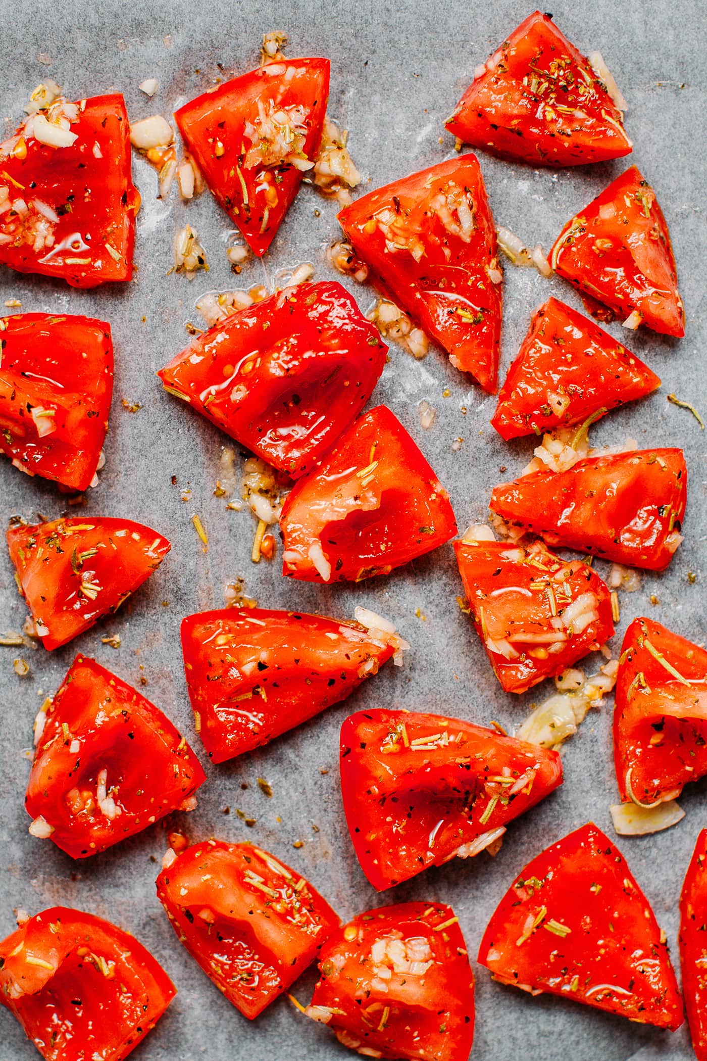 Cut tomatoes on a baking sheet.