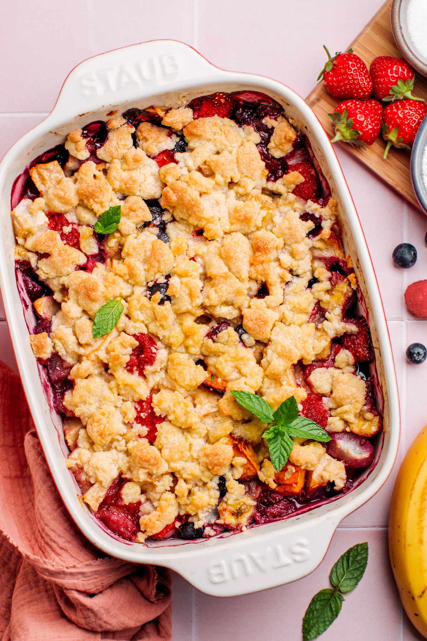 Close up of vegan fruit crumble topped with mint leaves.