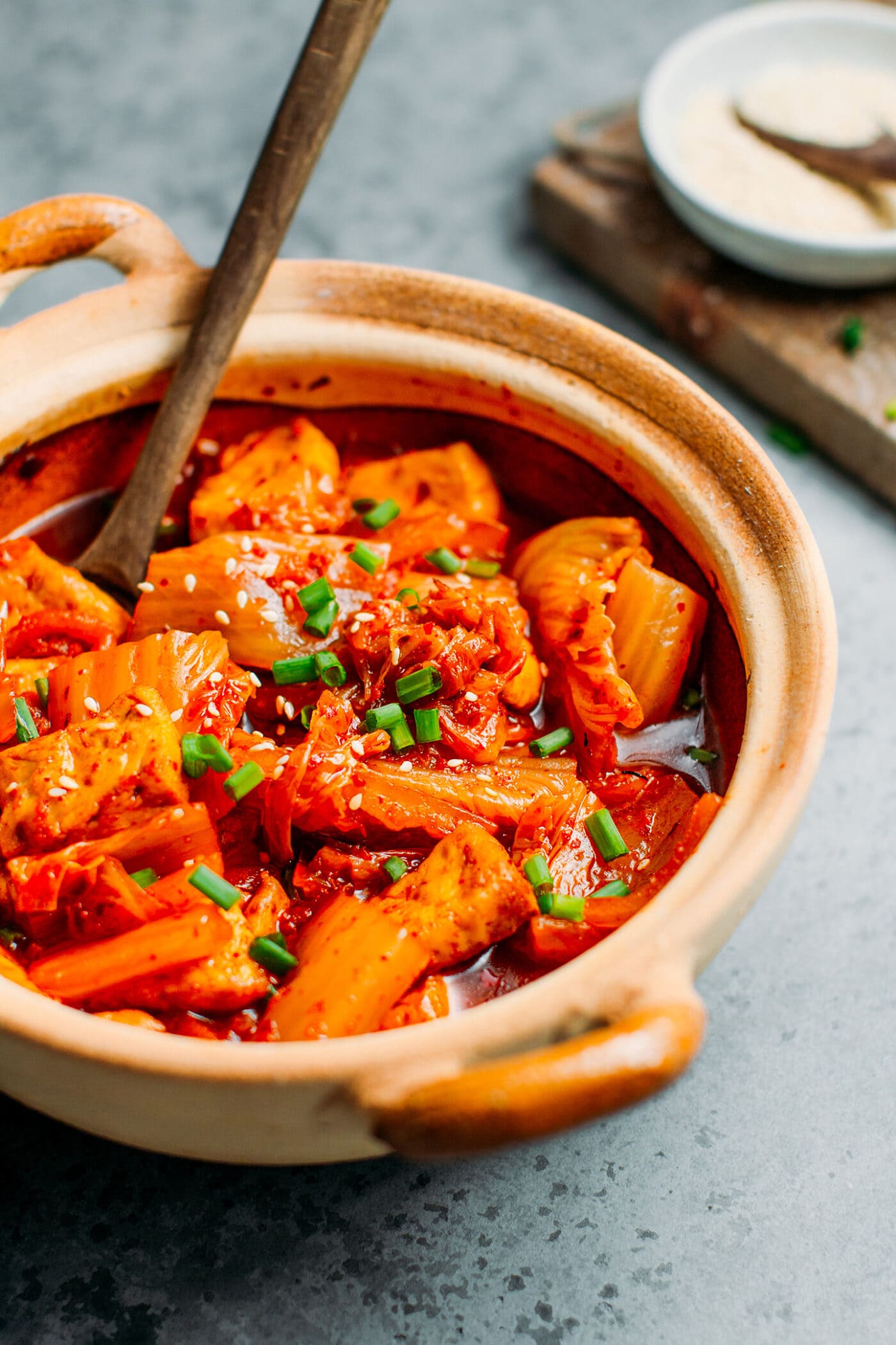 Close up of kimchi stew with green onions.