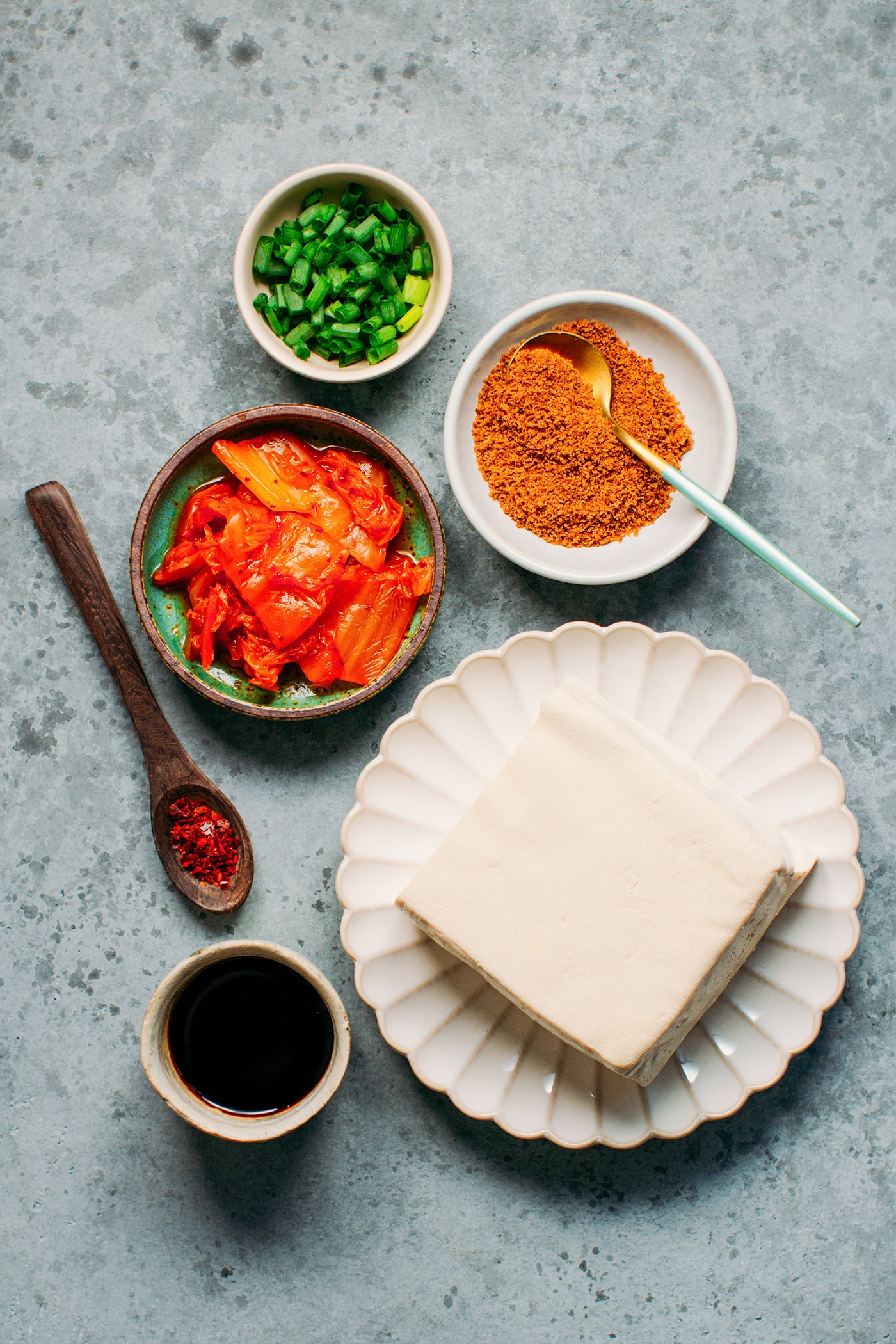 Ingredients like kimchi, tofu, soy sauce, coconut sugar, green onions.