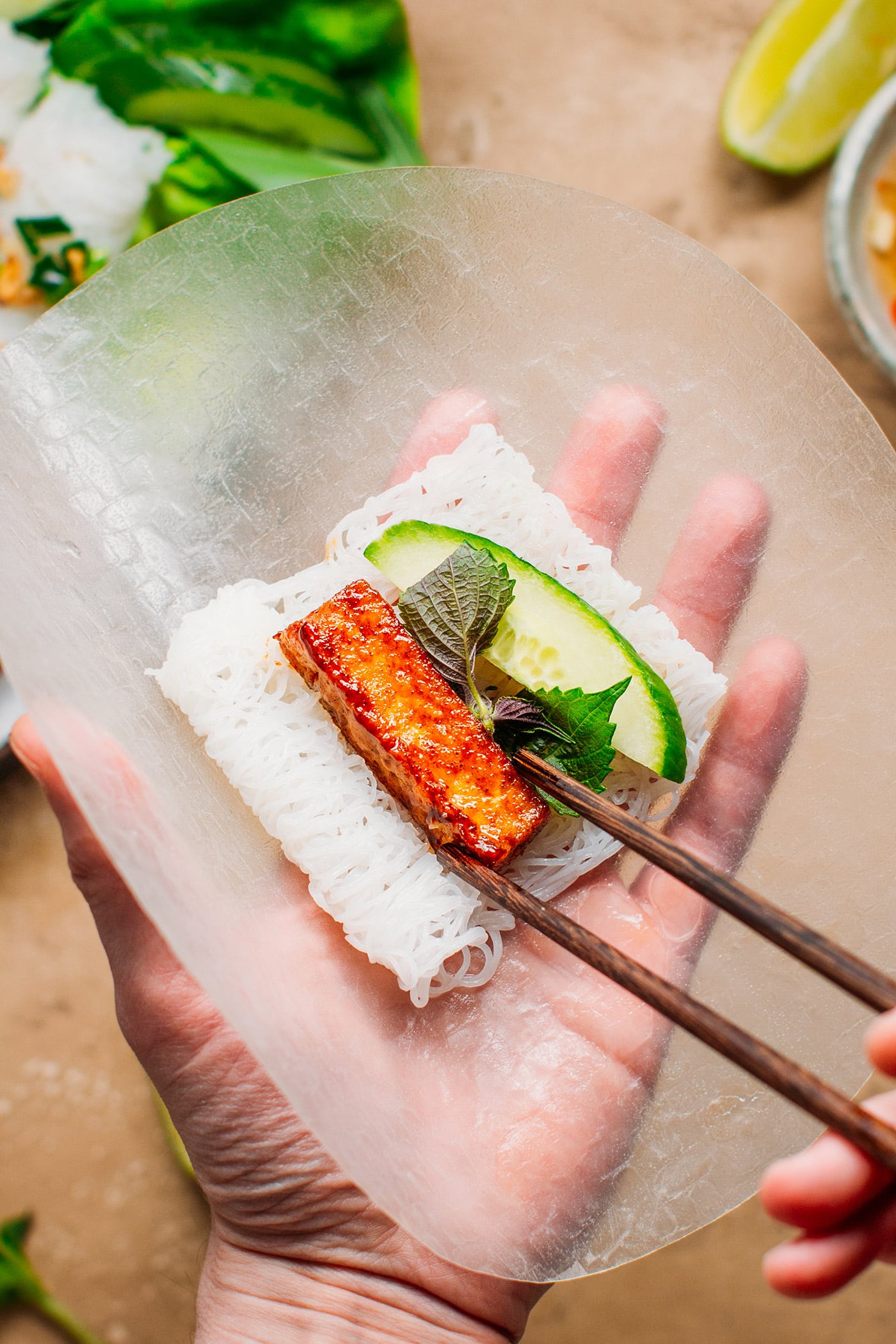 Rice paper sheet filled with rice vermicelli, tofu, cucumber, perilla leaves.