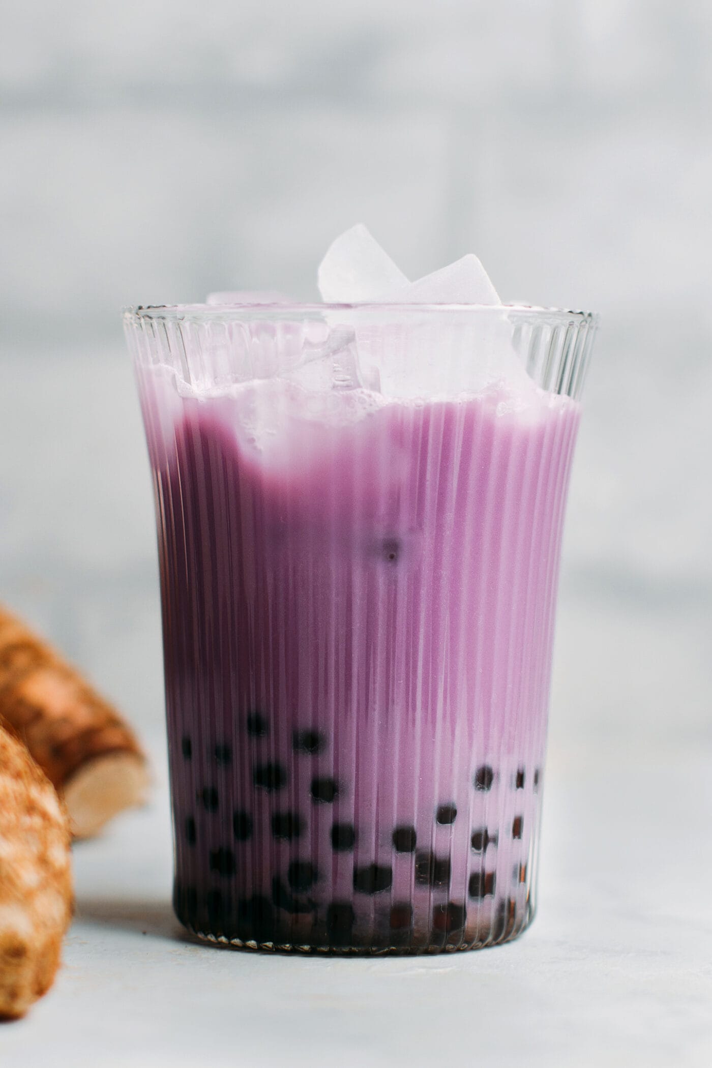 Glass of taro milk tea with boba.