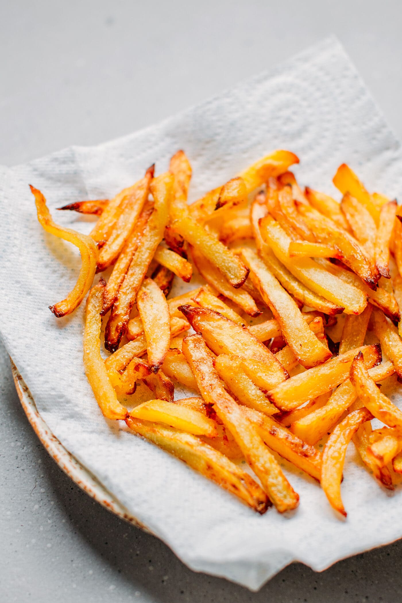 French fries on a plate lined with parchment paper.