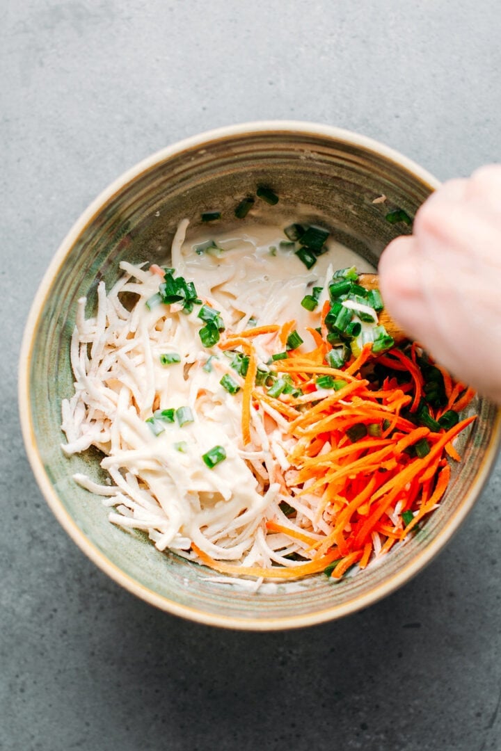 Fritter batter in a bowl with taro, green onions, and carrots.