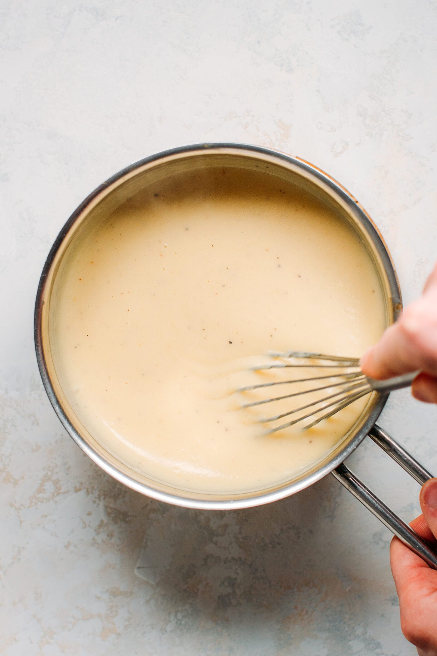 Preparing bechamel sauce in a saucepan.