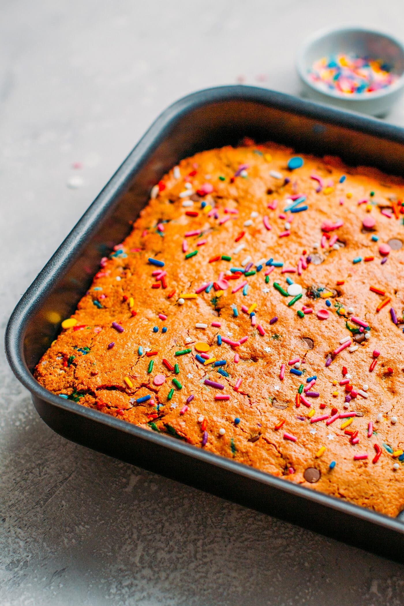 Baked vegan blondies topped with sprinkles.