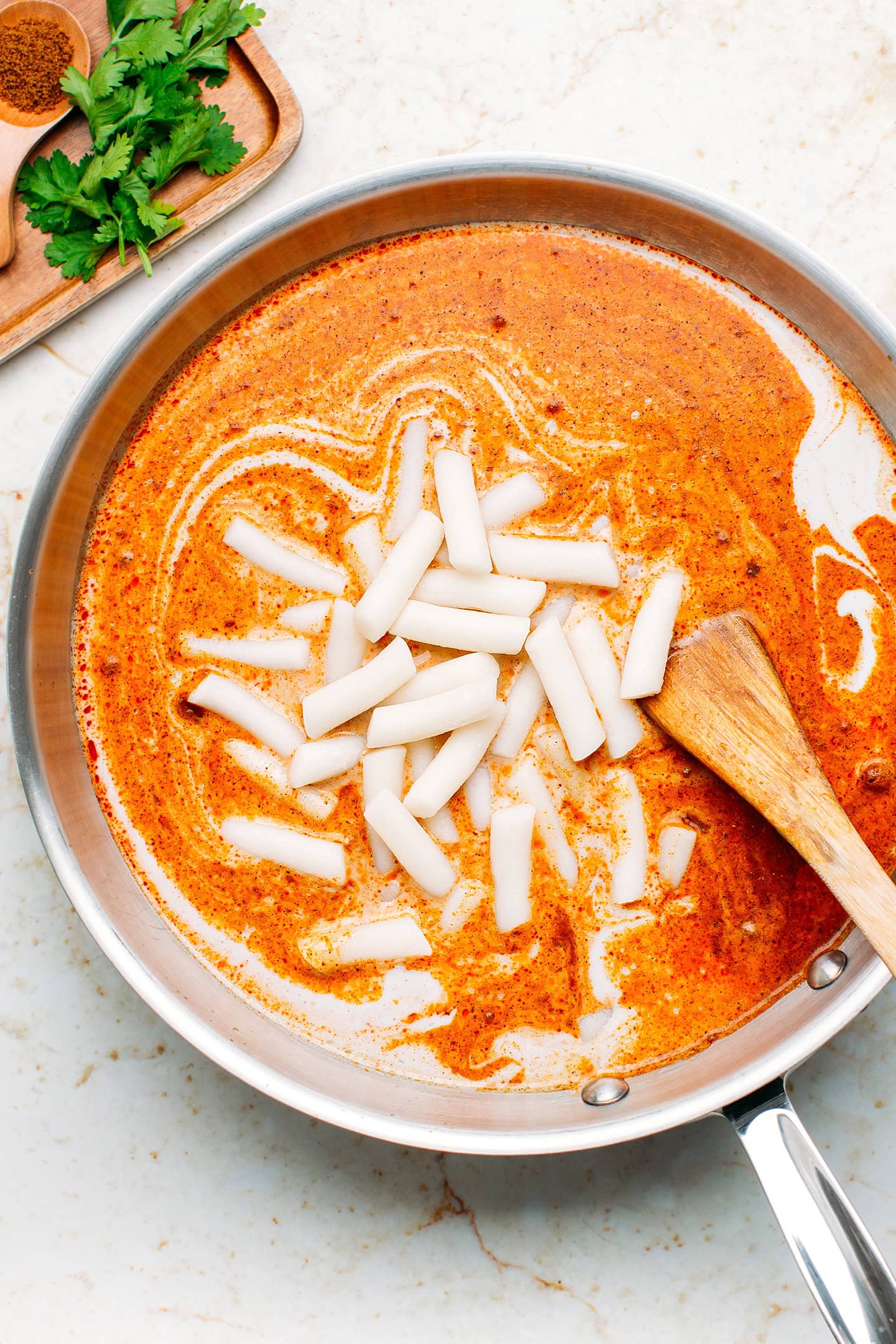 Curry sauce and rice cakes in a skillet.