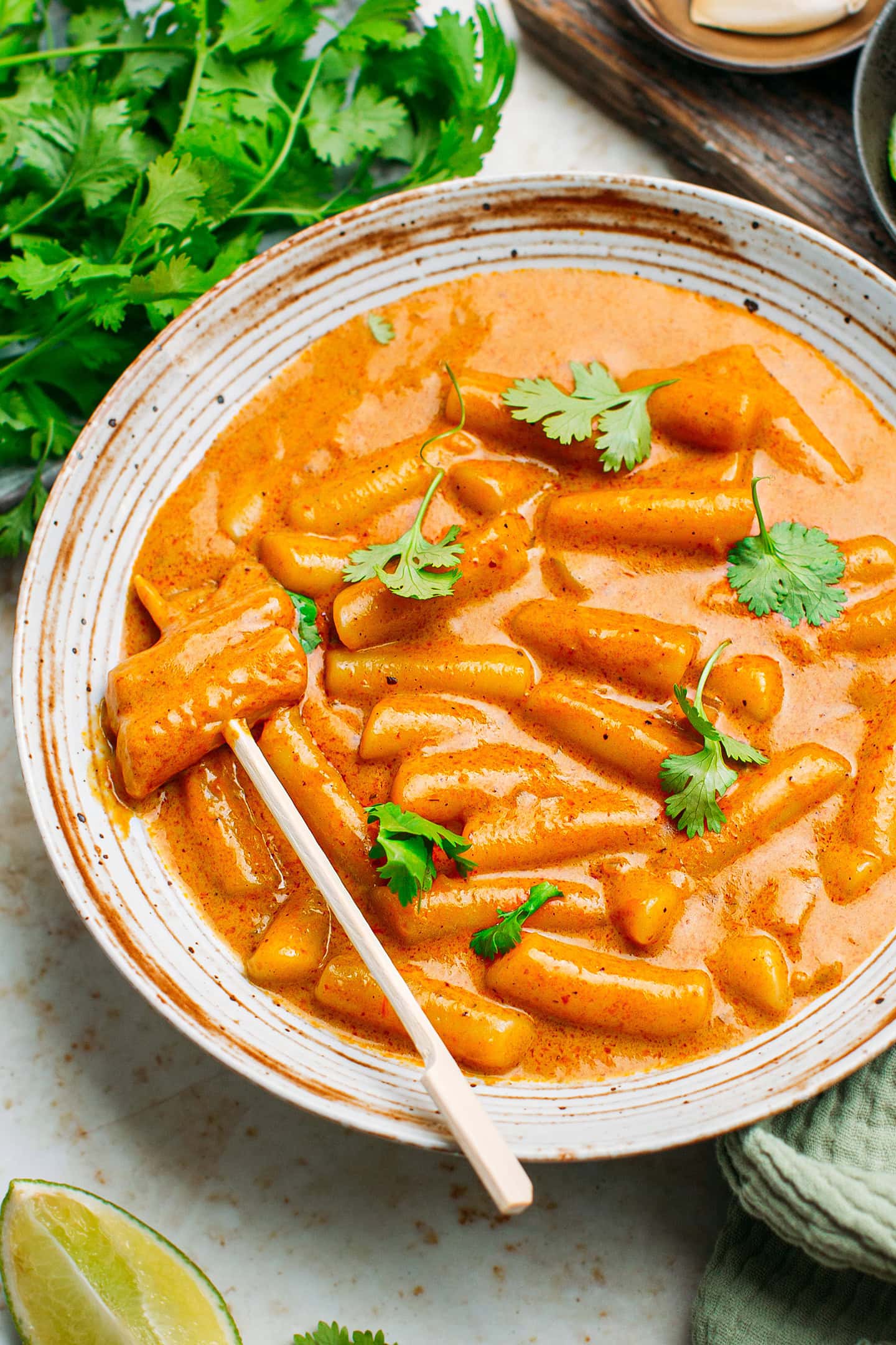 Sliced rice cakes in a red curry sauce.