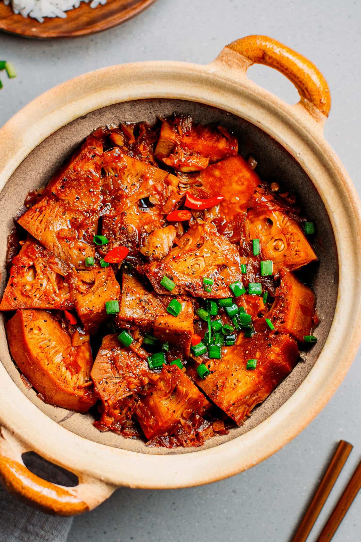 Braised jackfruit with green onions in a clay pot.