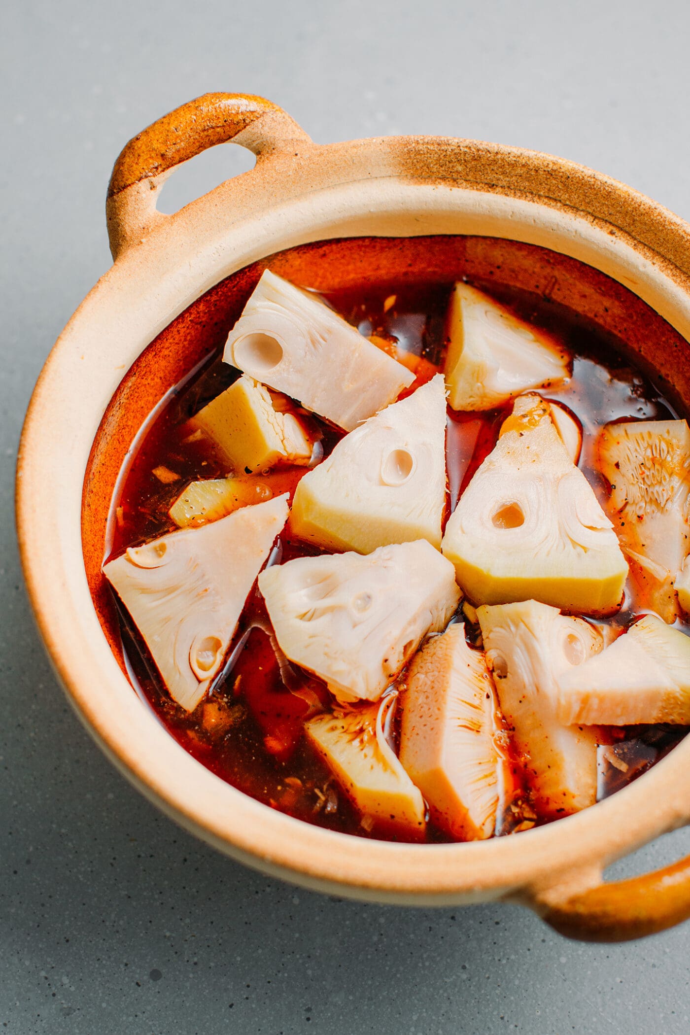 Green jackfruit with soy sauce in a clay pot.