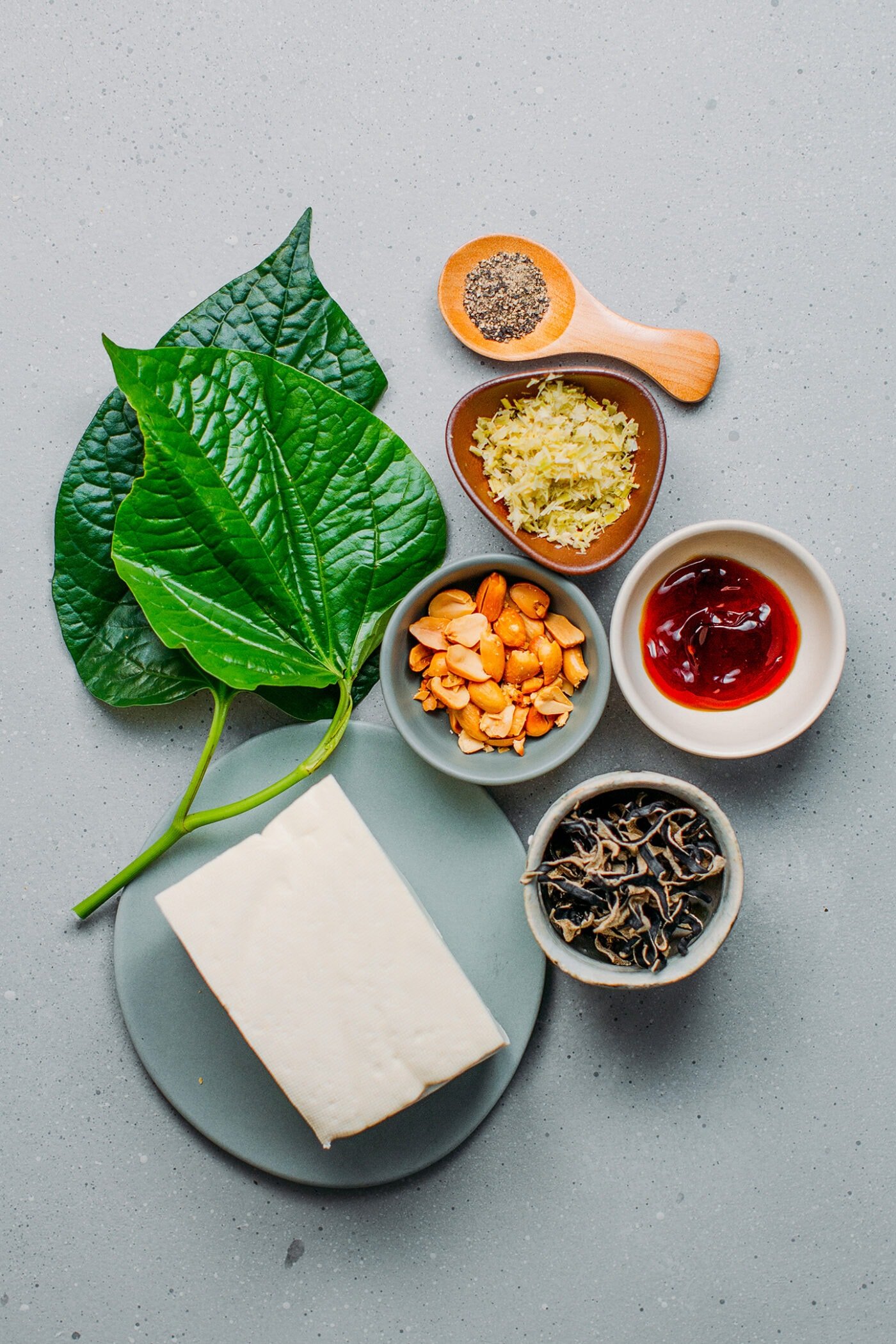 Ingredients like betel leaves, tofu, black mushrooms, lemongrass, peanuts.