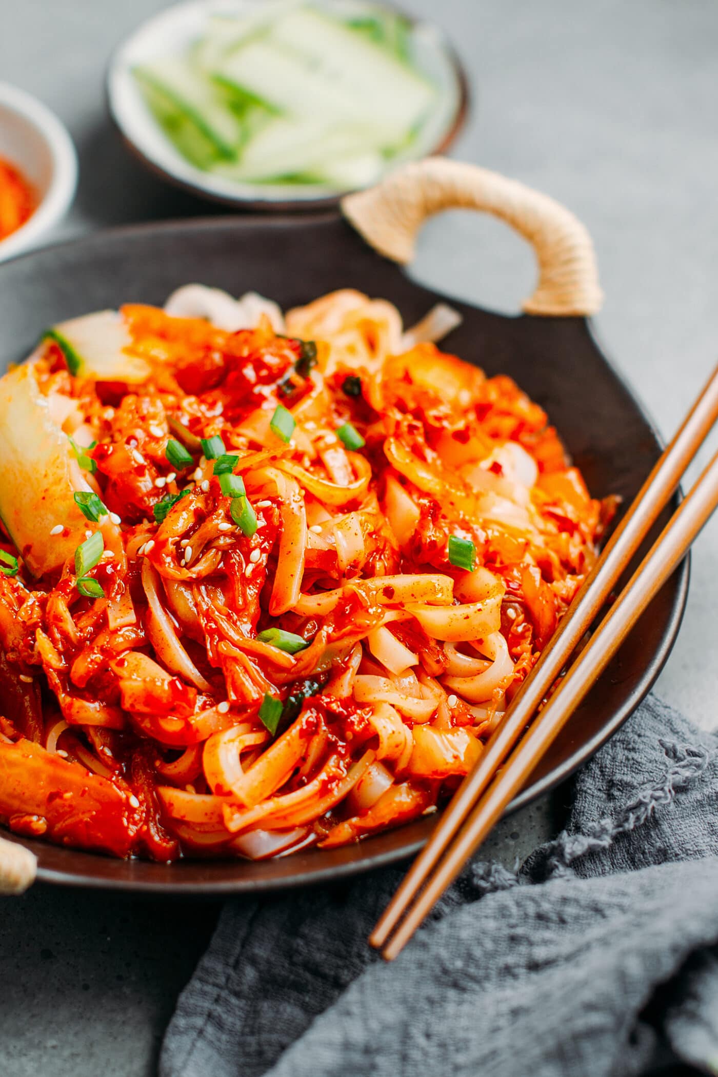 Kimchi Bibim Guksu in a plate with green onions.