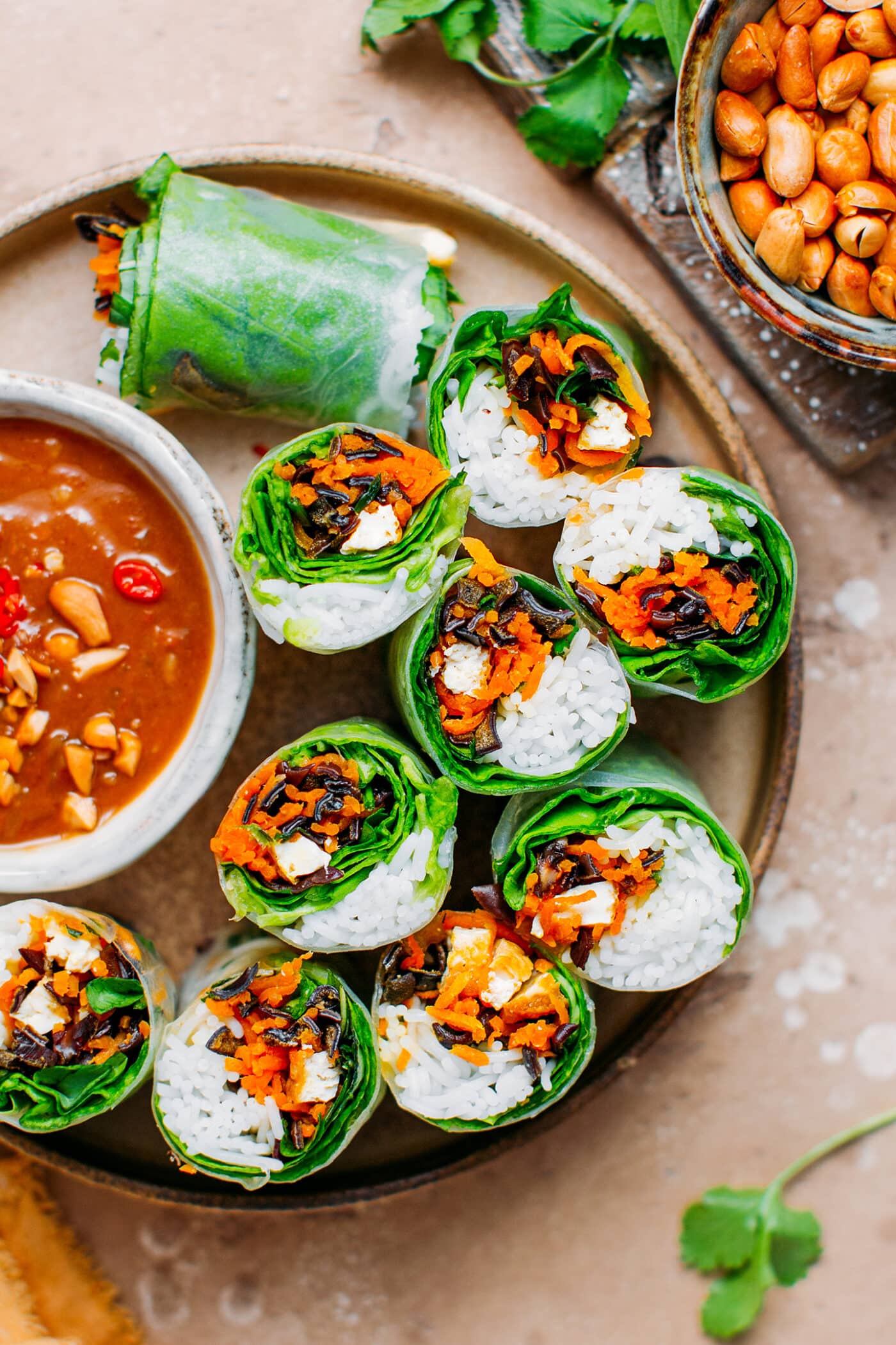 Vegan spring rolls filled with rice noodles, carrots, lettuce, and mushrooms.