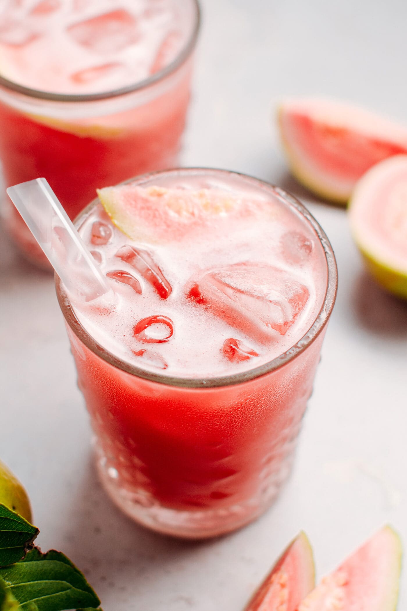 Close up of guava jasmine iced tea with ice in a glass.