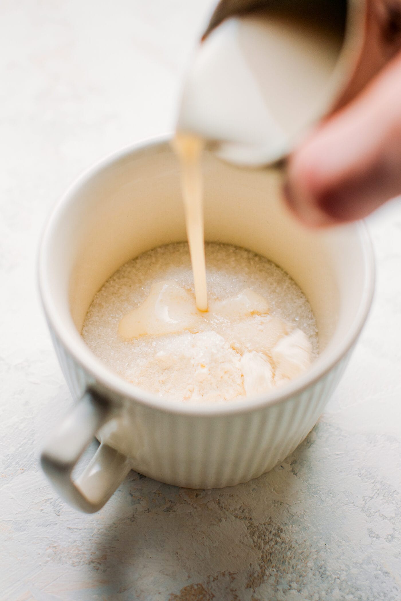 Pouring almond milk into a mug.